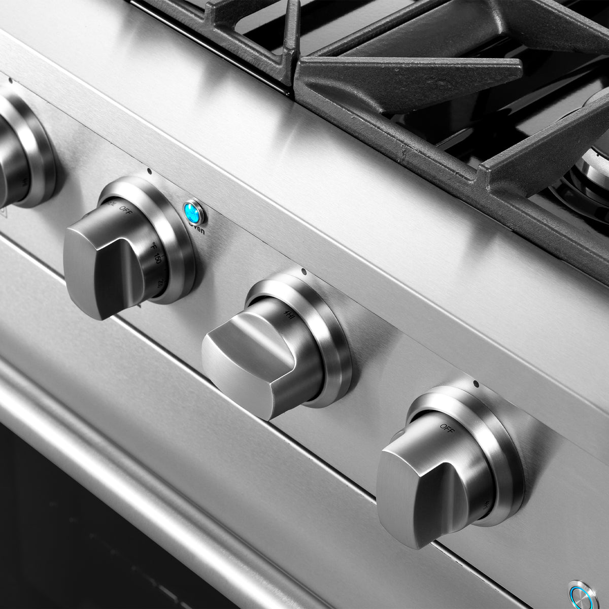 Close-up of stainless steel control knobs on gas range front panel