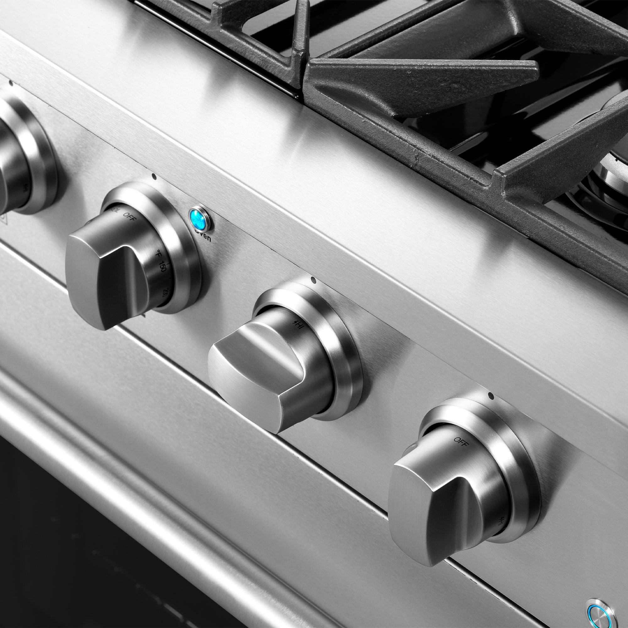 Stainless steel gas range control knobs with burner grates and black cooktop rings