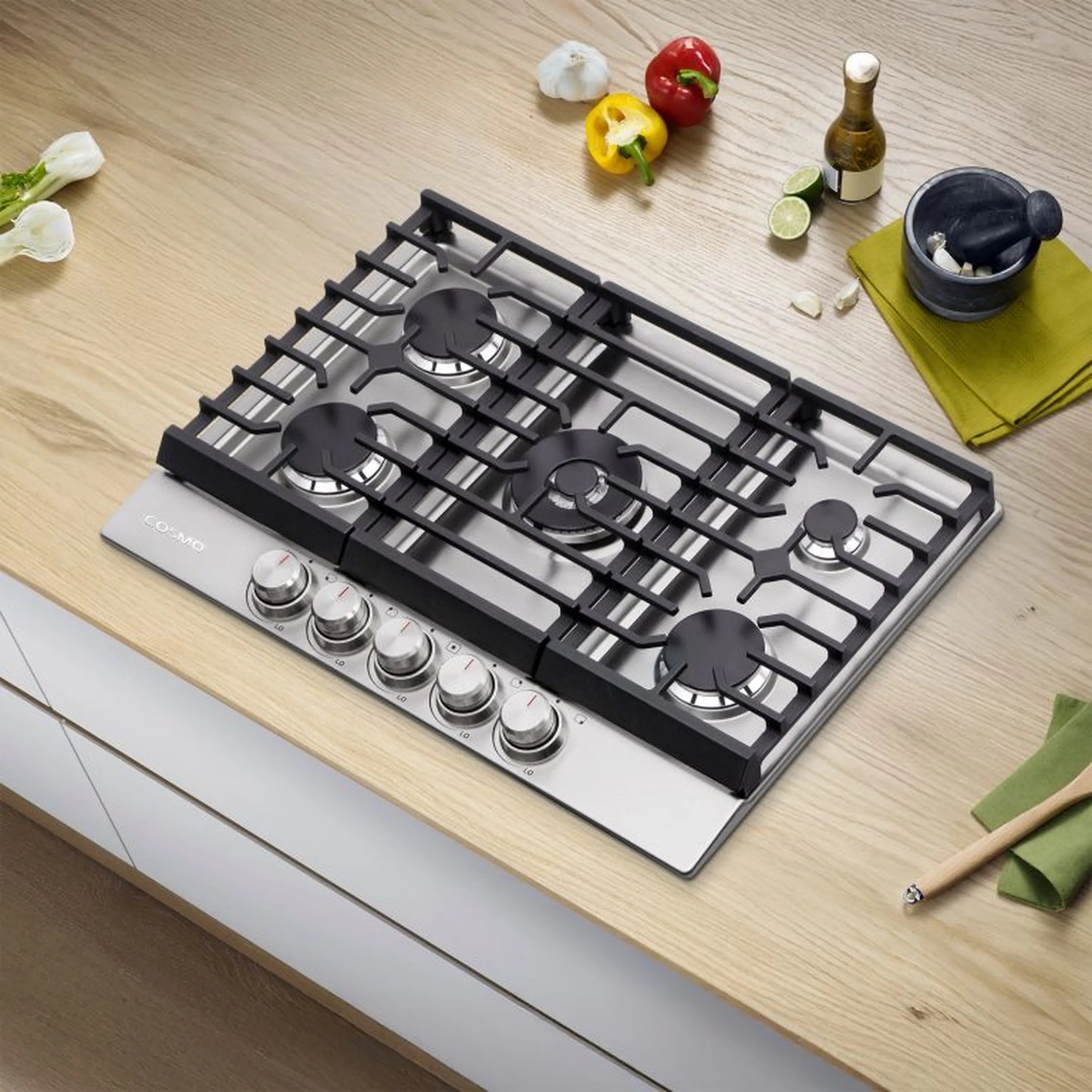 Stainless steel gas cooktop with black grates, multiple knobs, and burner caps