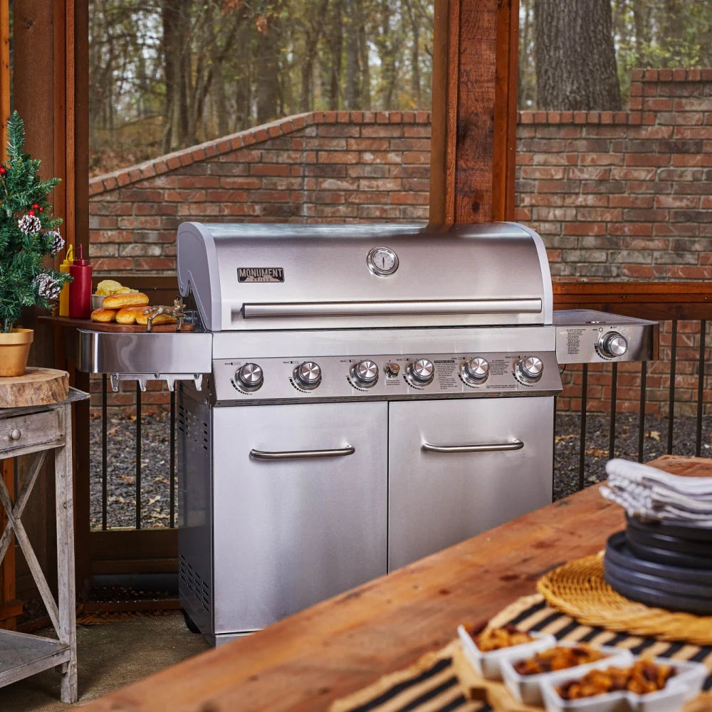 Stainless steel propane gas grill with lid closed and six front burner knobs