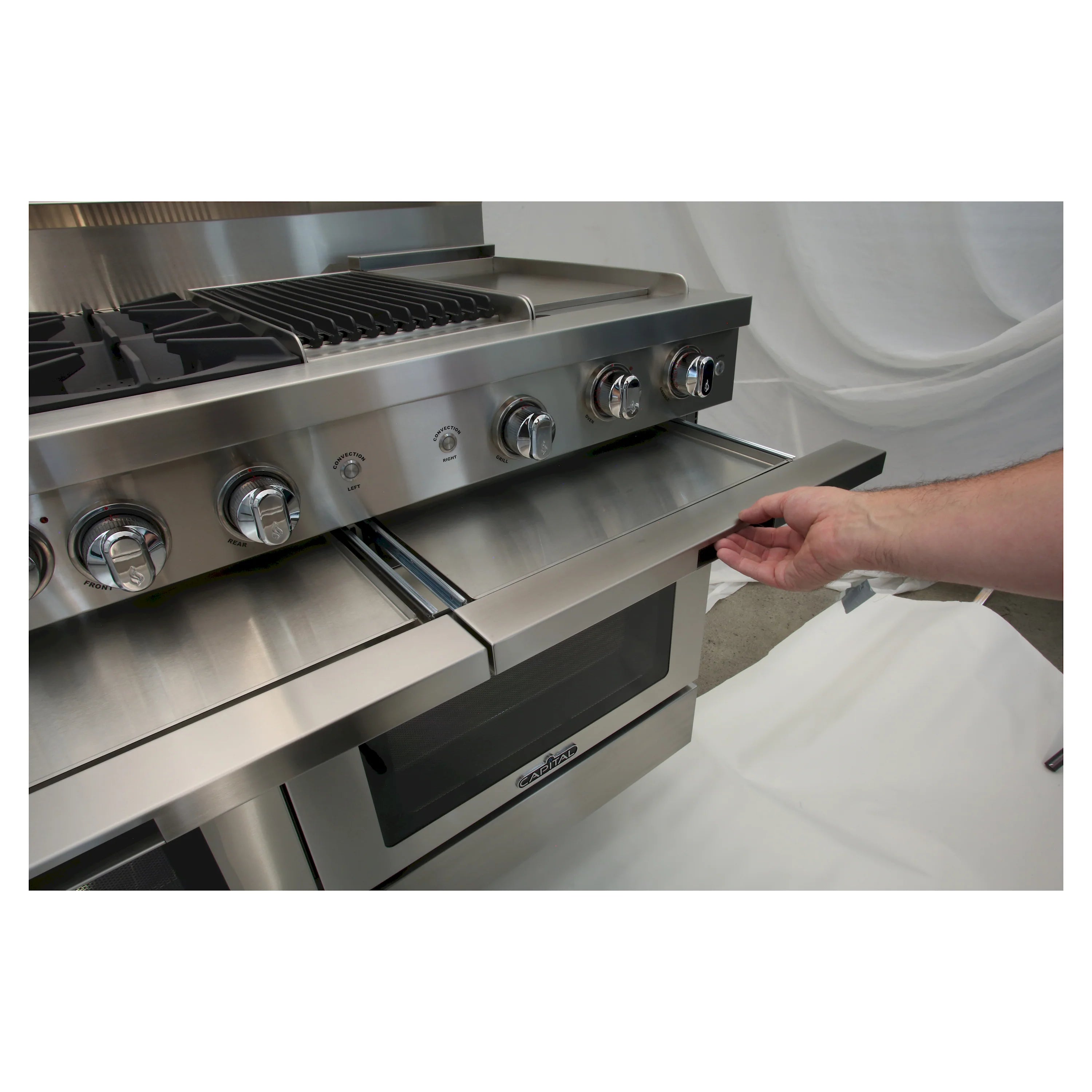 Hand opening griddle drawer on stainless steel gas chef range with control knobs