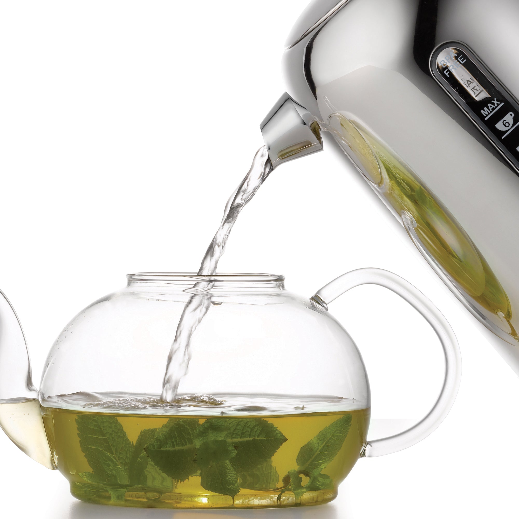 Polished chrome kettle pouring clear water from spout into a glass teapot.