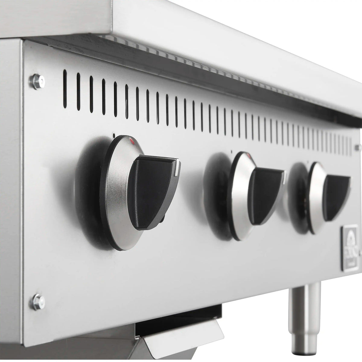 Close-up of stainless steel gas griddle controls with black knob handles