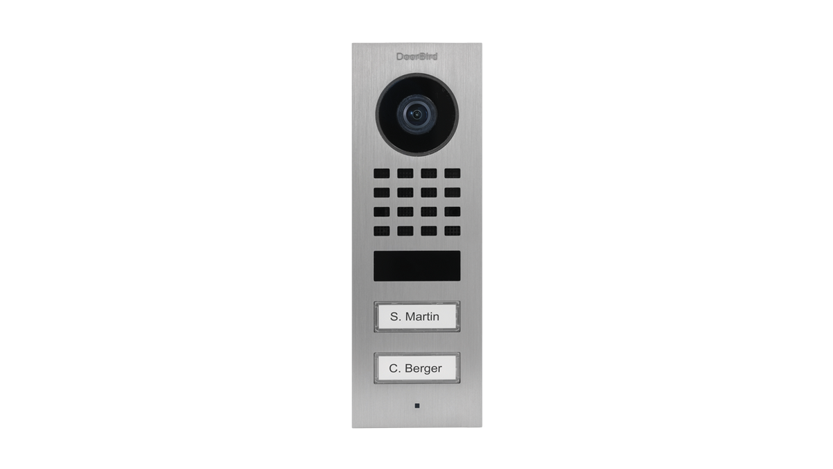 DoorBird surface-mount video door station in dark metal with camera, grille and button labels