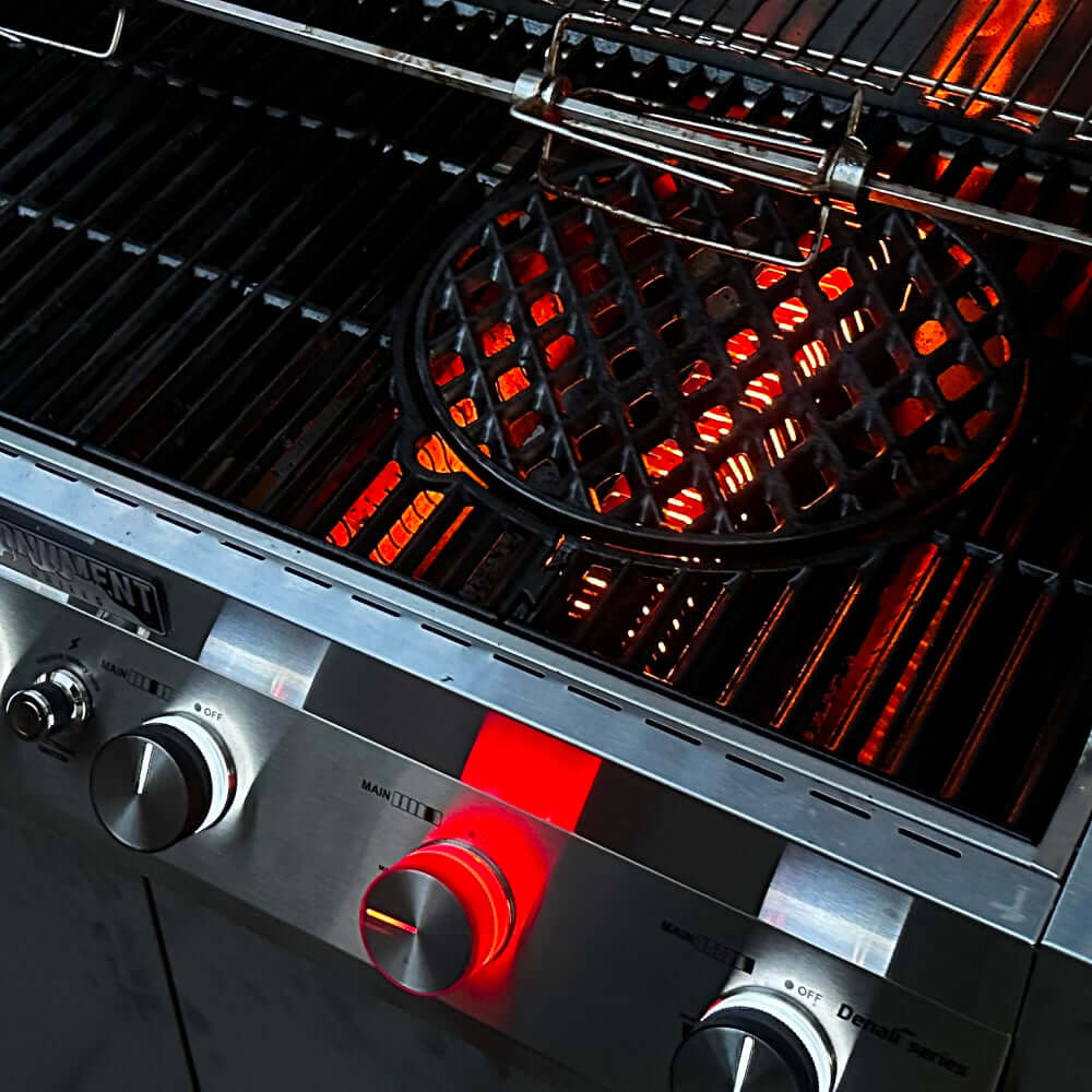 Gas grill burner area with glowing red flames under the cooking surface
