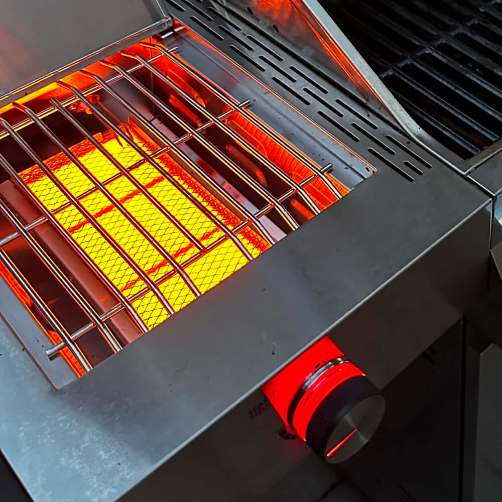 Stainless propane gas grill with open lid and lit burners under wire cooking grates