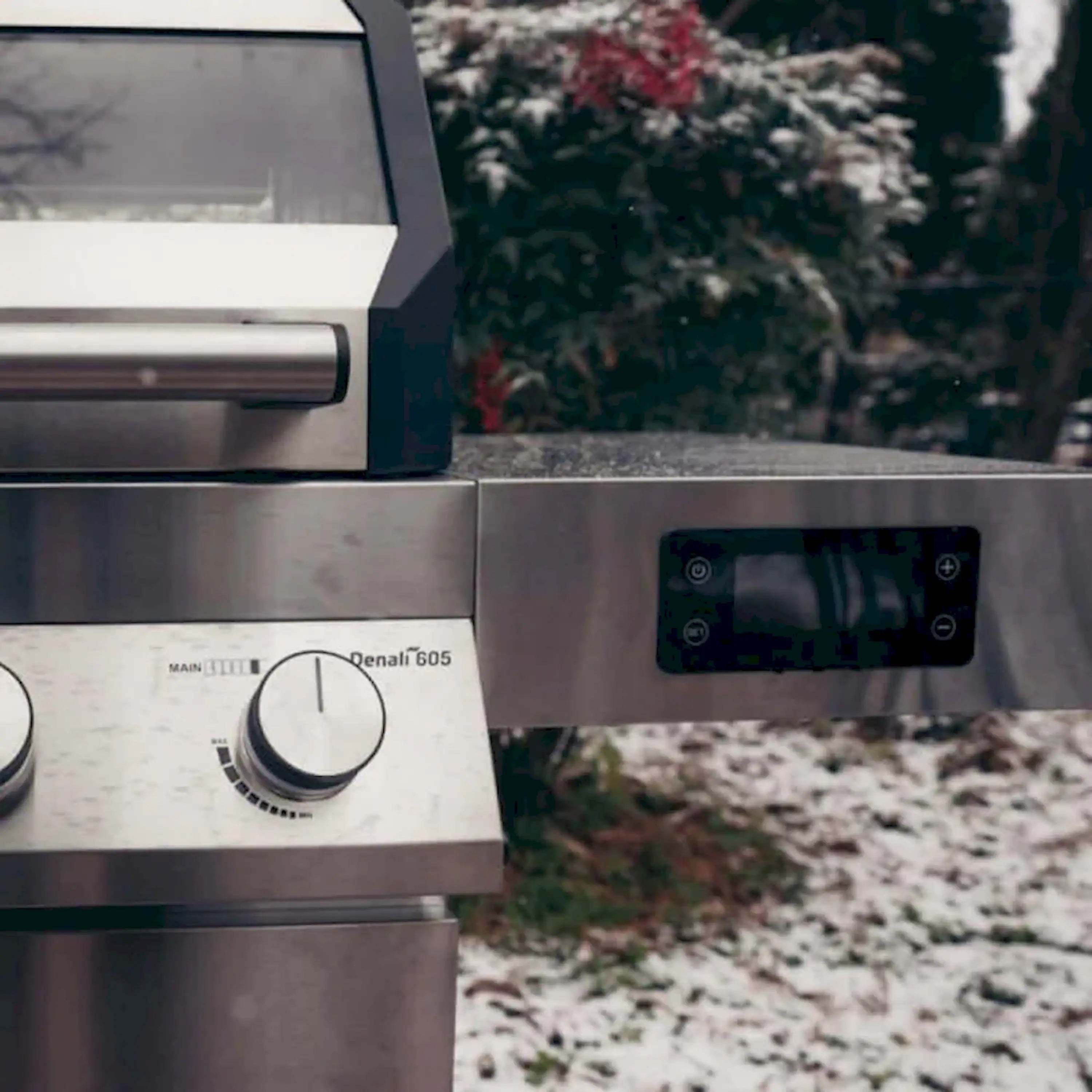 Stainless gas grill side panel with control knob and Denali 605 label