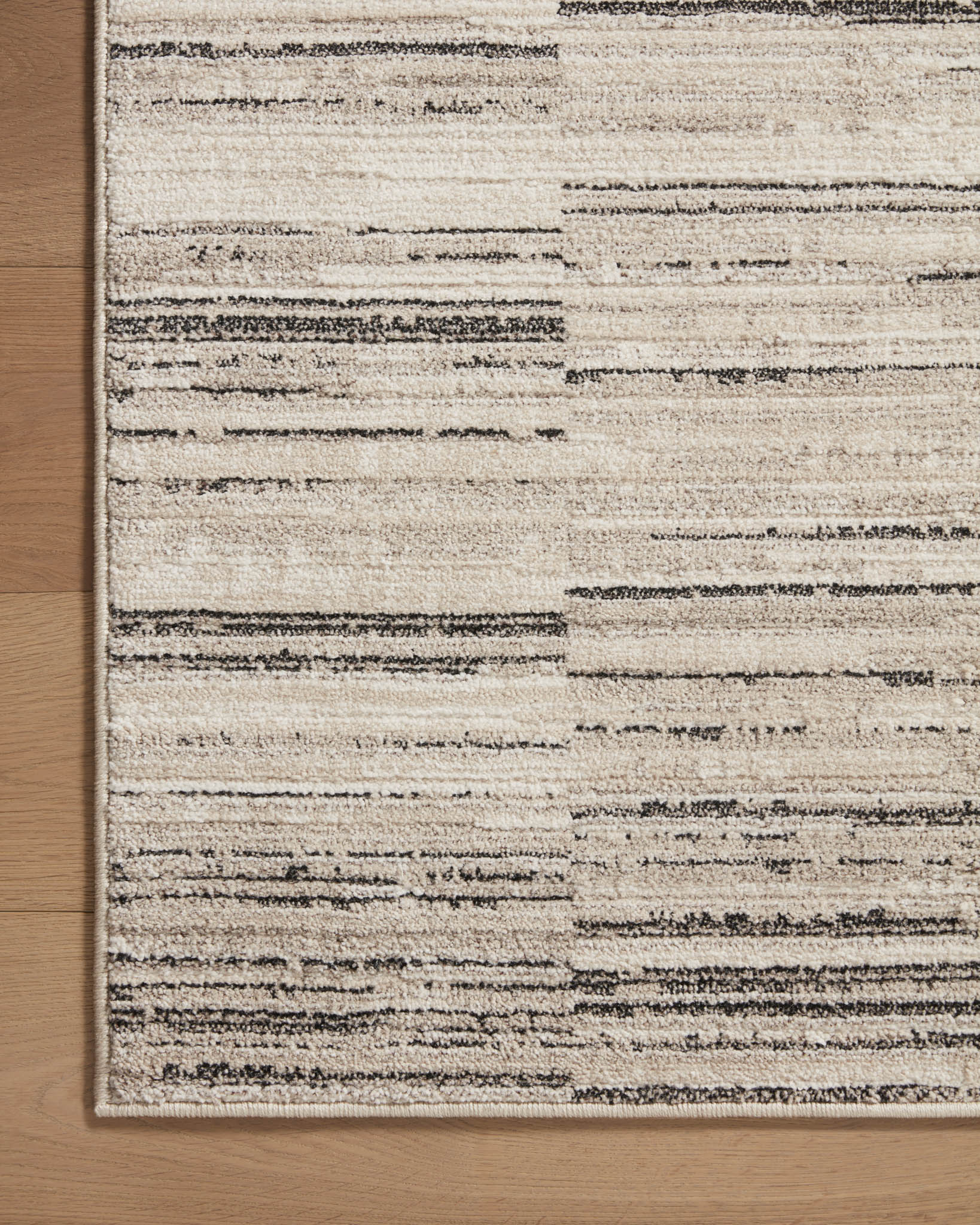 Charcoal and sand area rug with rectangular border and horizontal striped distress
