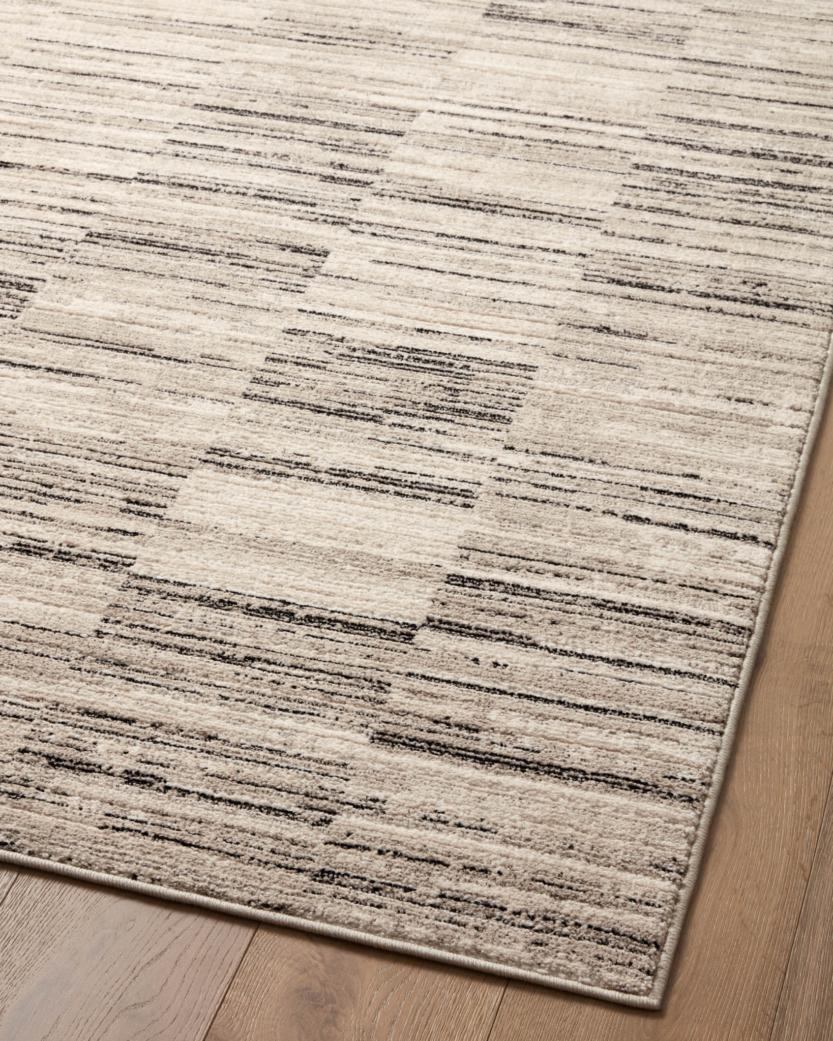 Charcoal and sand area rug surface with horizontal stripes and distressed detailing