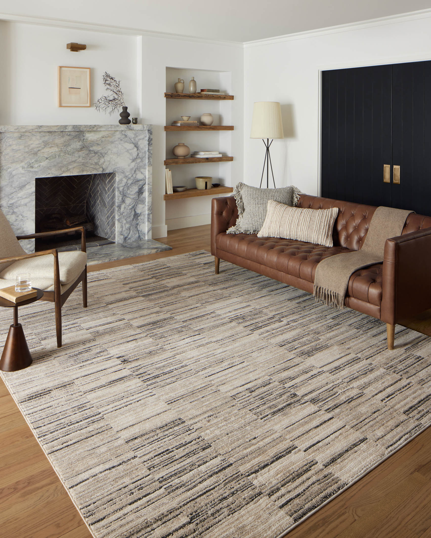 Charcoal and sand area rug on hardwood floor with linear textured stripe pattern