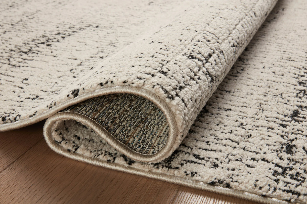 Rolled edge detail of oatmeal and charcoal runner rug with fringe binding