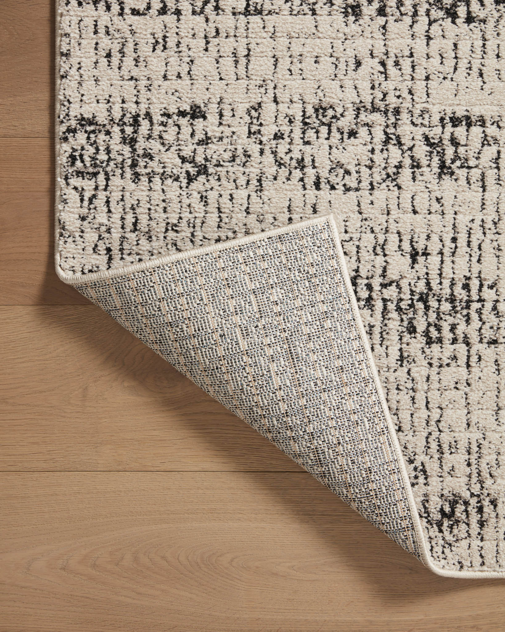 Oatmeal and charcoal runner rug edge with woven border and detailed texture