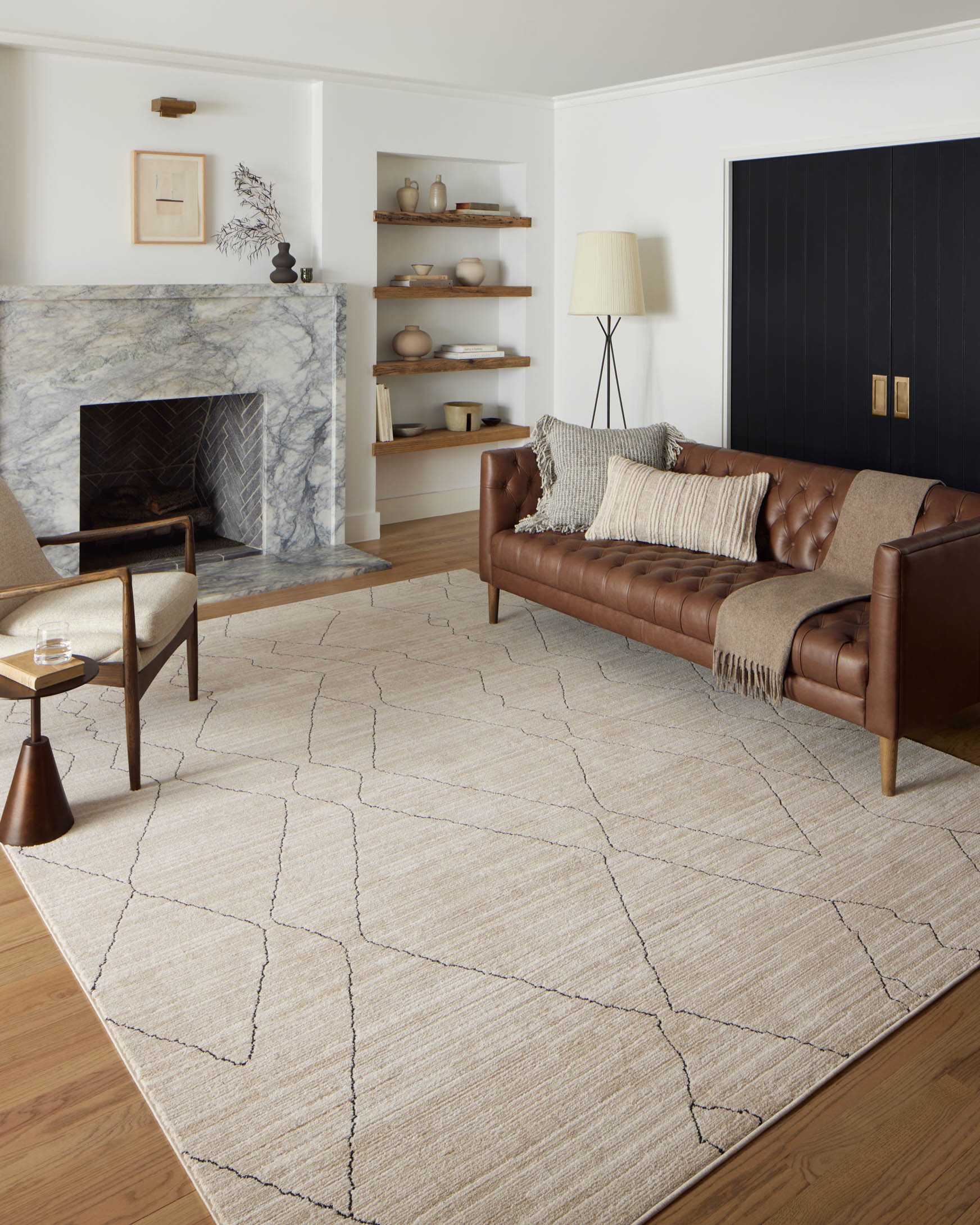 Sand area rug with charcoal geometric lattice lines, large corner and border view