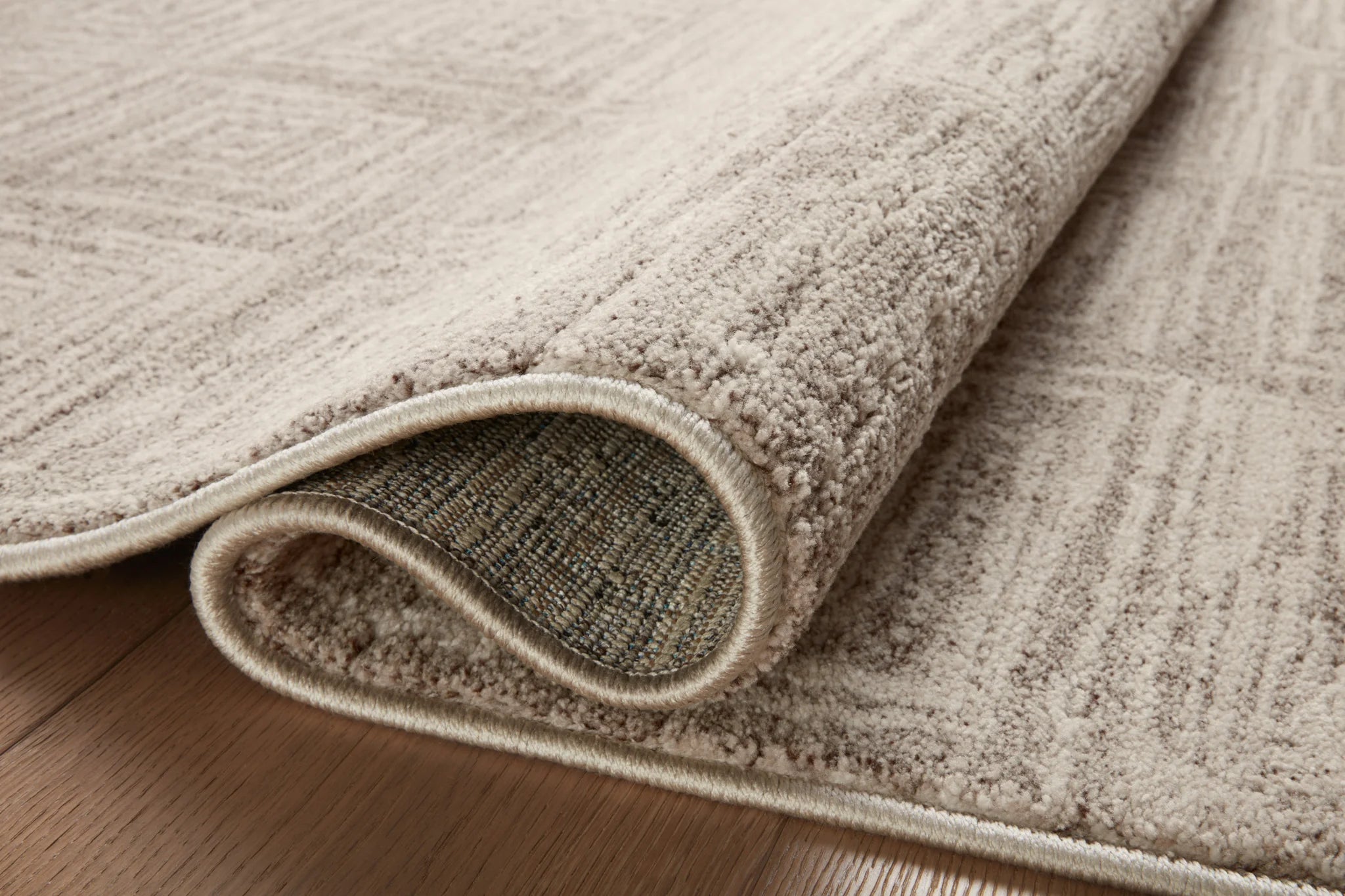 Beige and gray area rug rolled edge detail, textured border and underside view