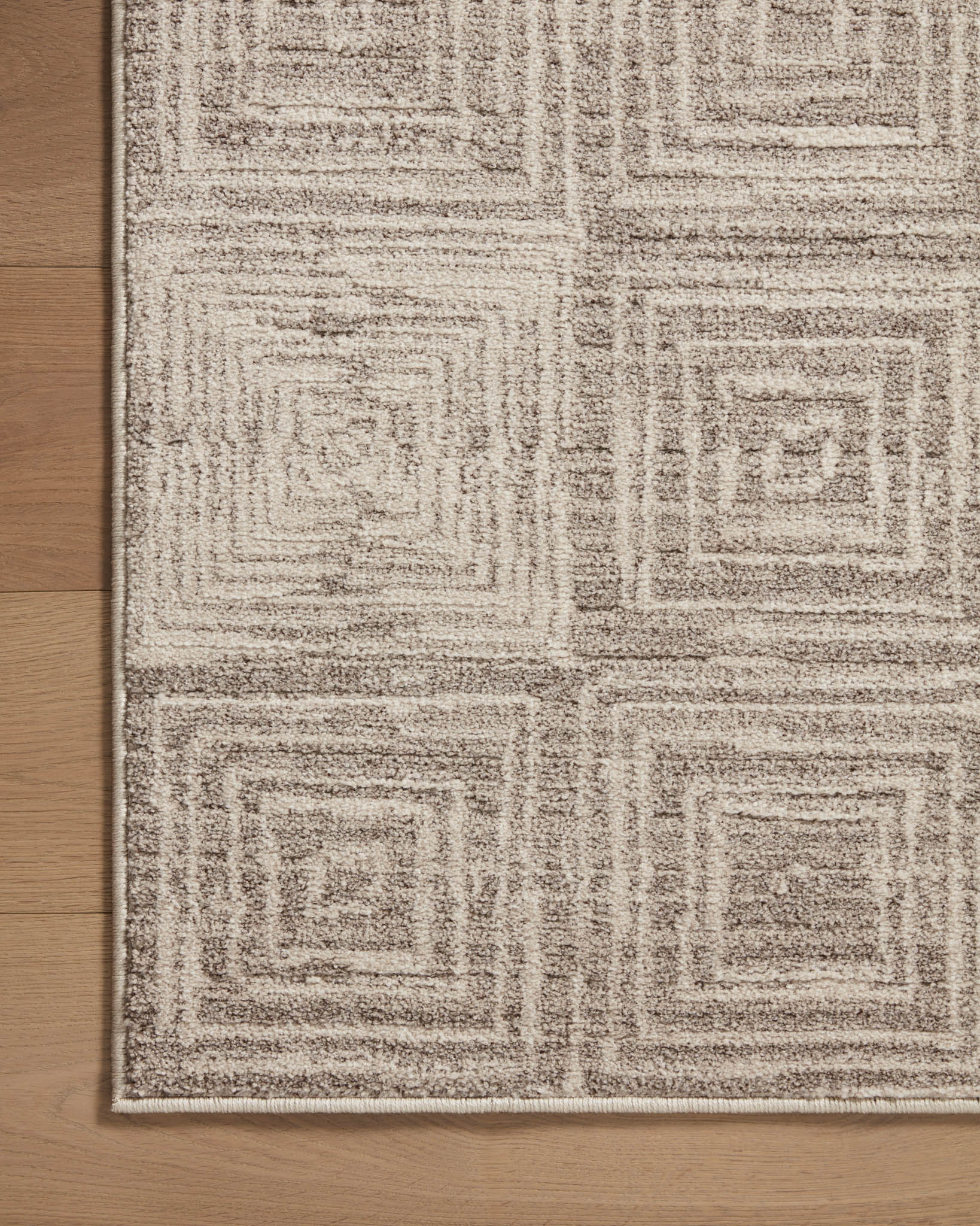 Beige and gray geometric area rug with repeating square maze motif.