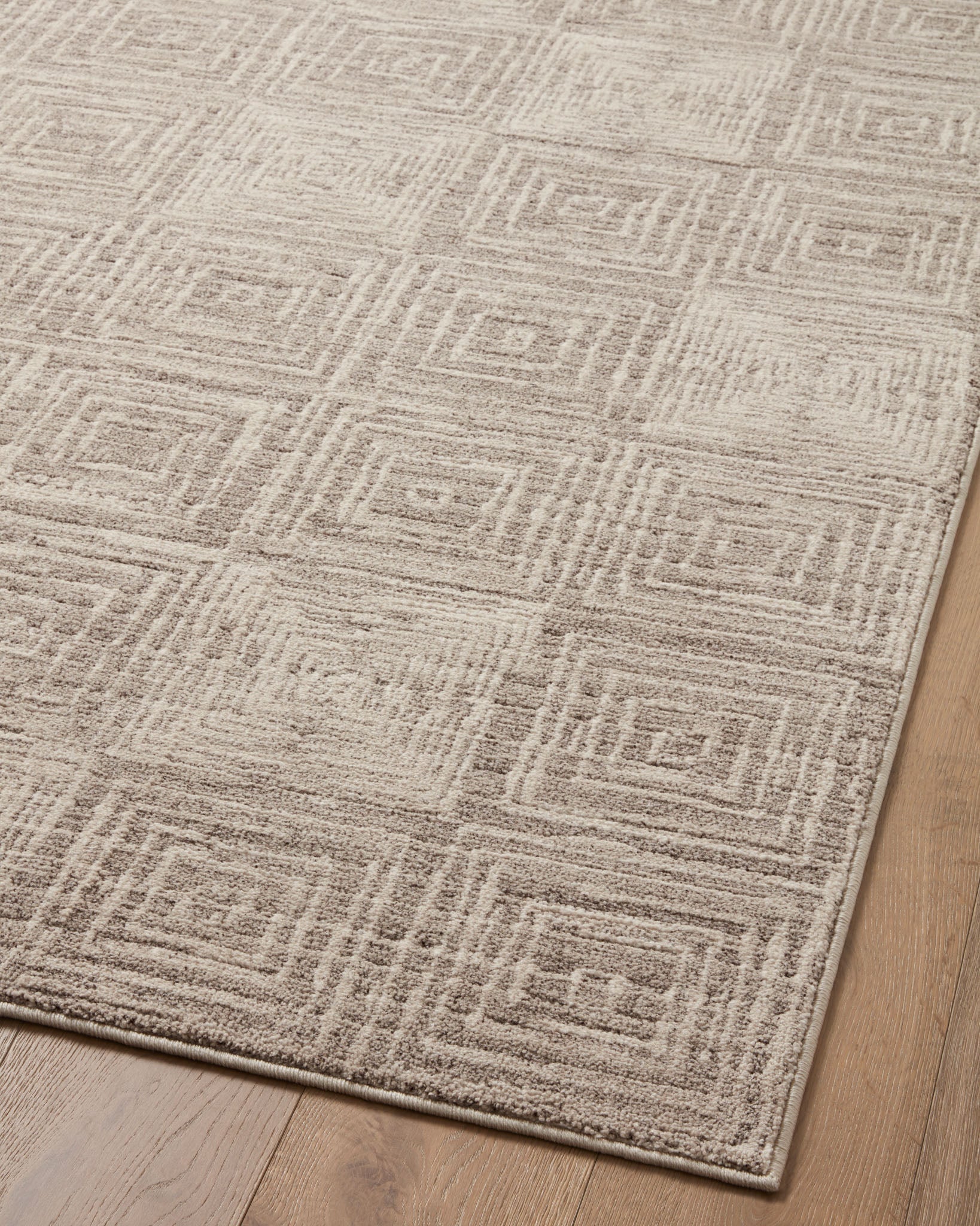 Beige and gray area rug close-up of repeating geometric Greek-key pattern