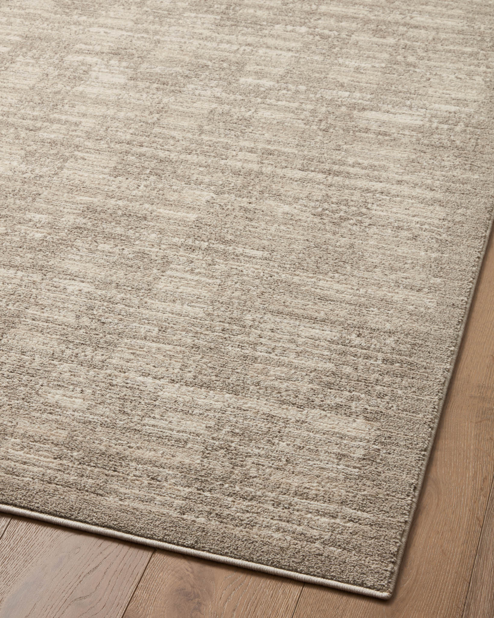 Sand-beige runner rug corner with textured flat weave and thin border trim