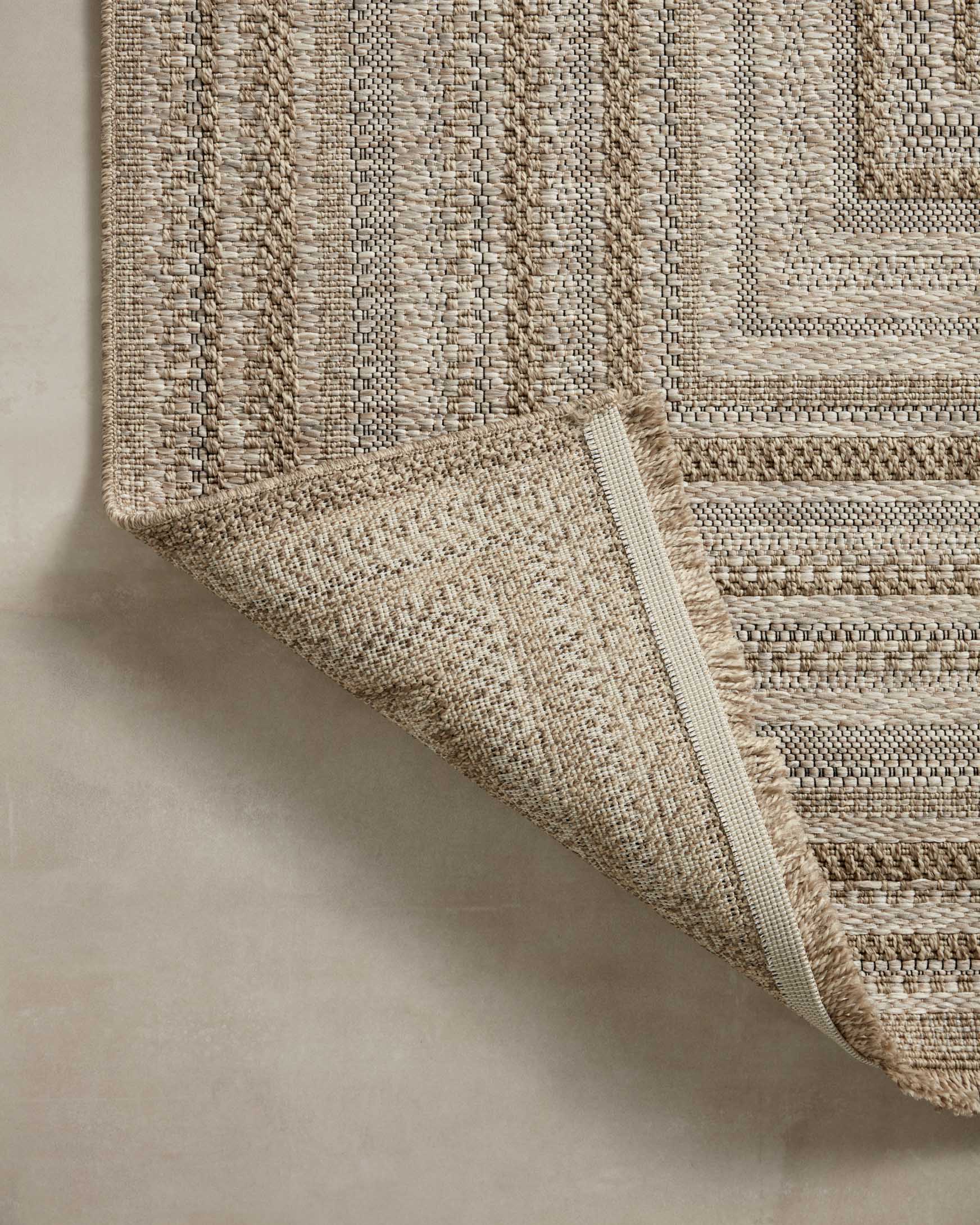 Natural woven rug corner detail with geometric line pattern and short fringe