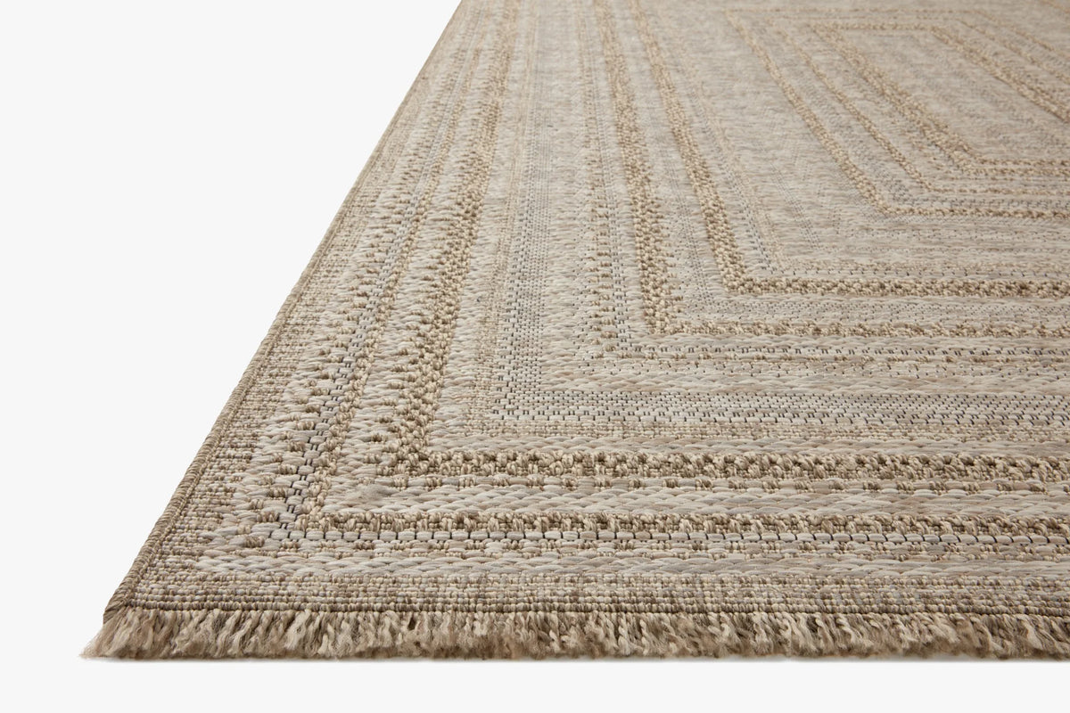 Natural area rug with braided geometric border pattern, fringed edges