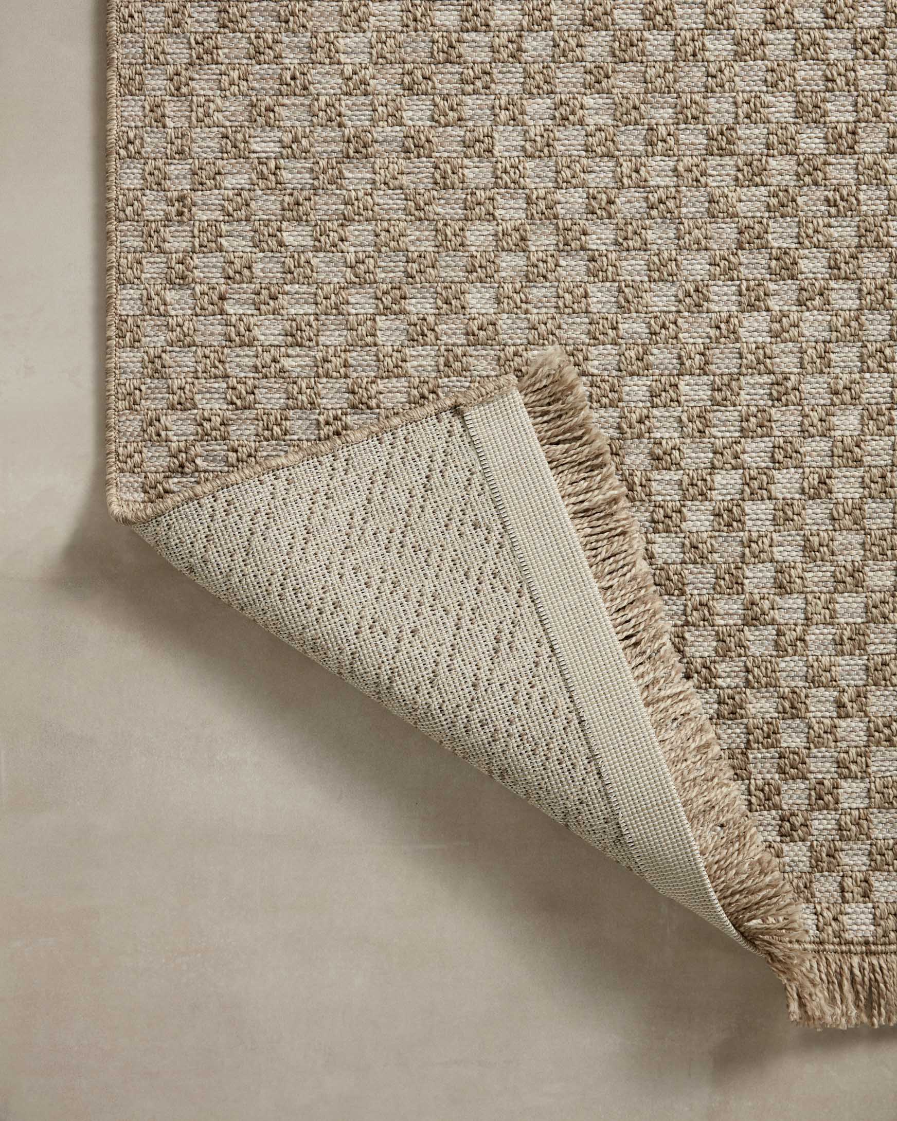 Natural rug edge with fringed border and visible woven backing