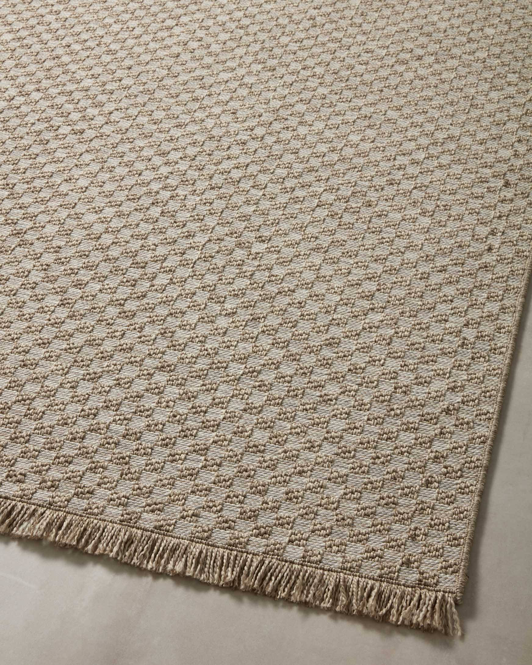 Natural area rug with small woven pattern and short fringe trim at the border