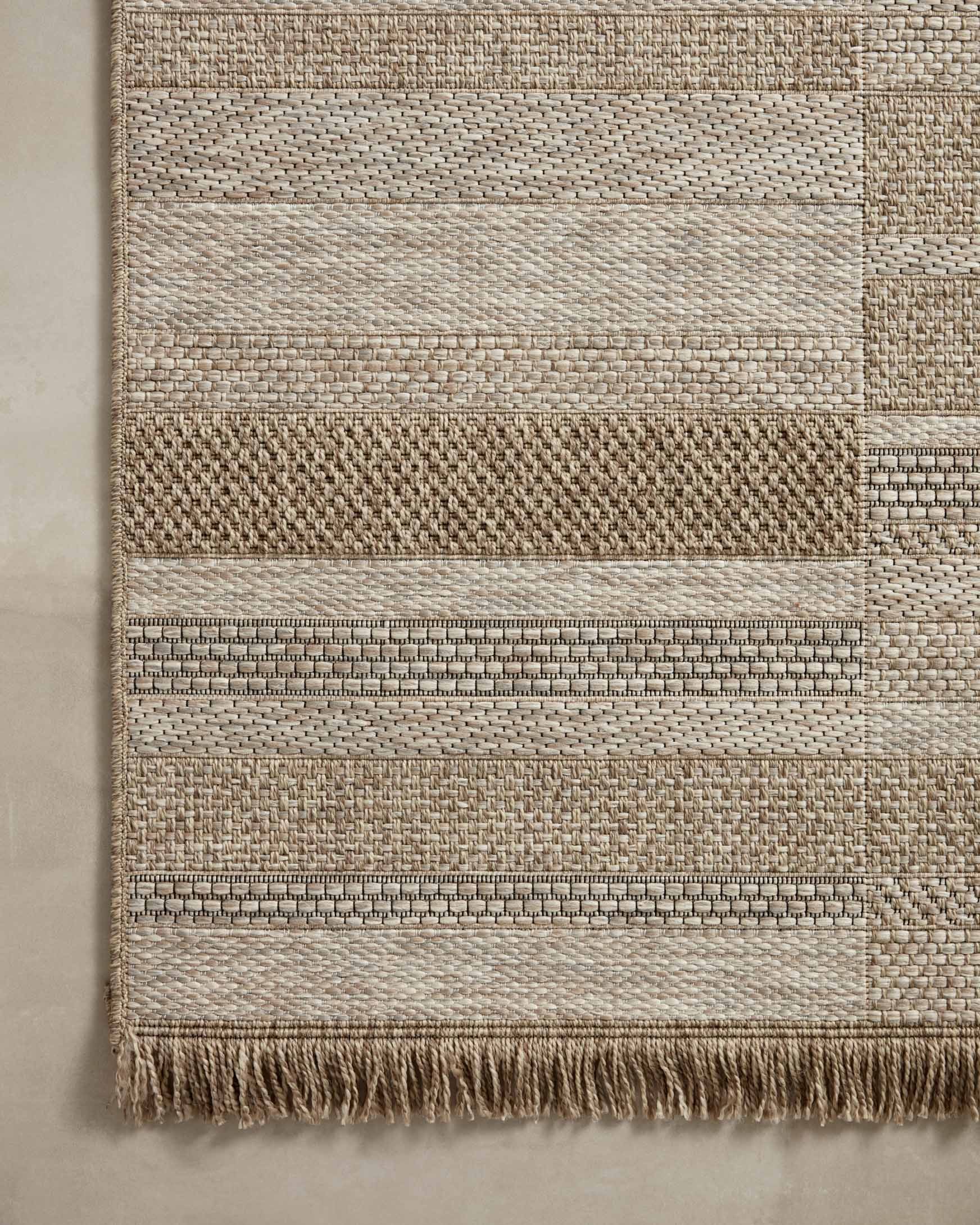 Natural woven rug with horizontal stripe bands and short fringe edge