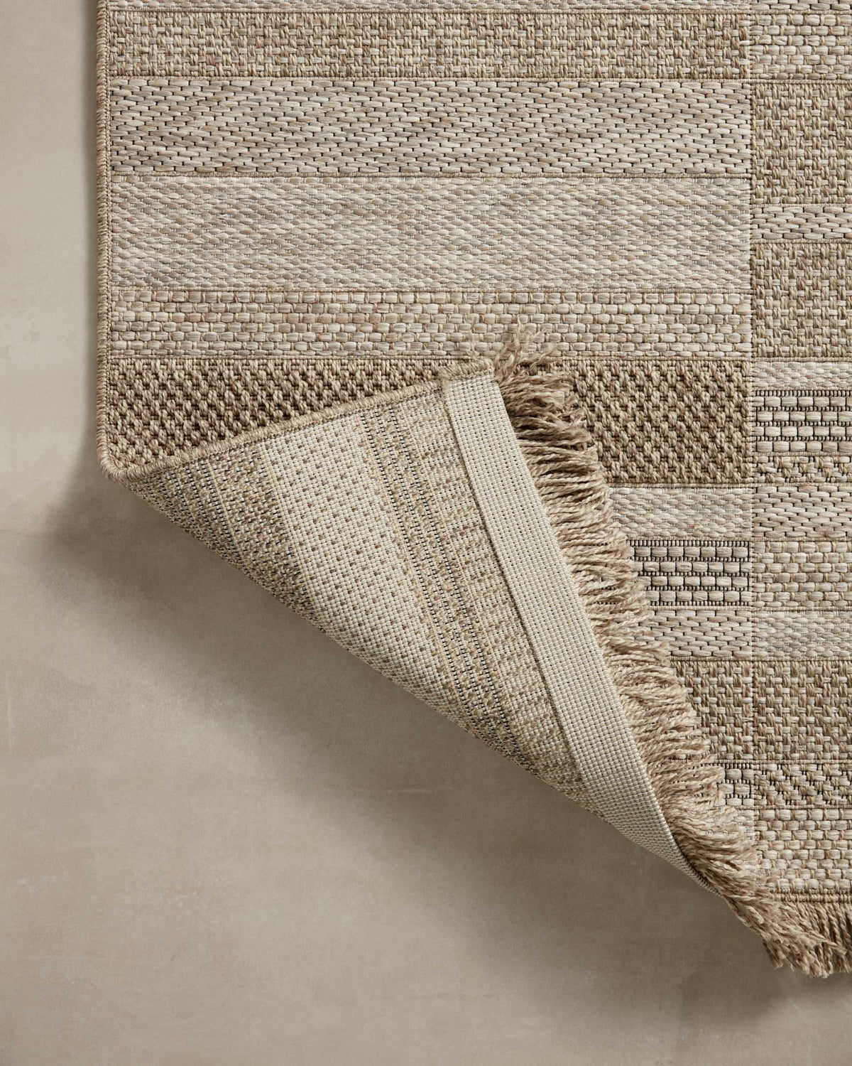 Natural woven runner rug with angled fold detail and fringe trim