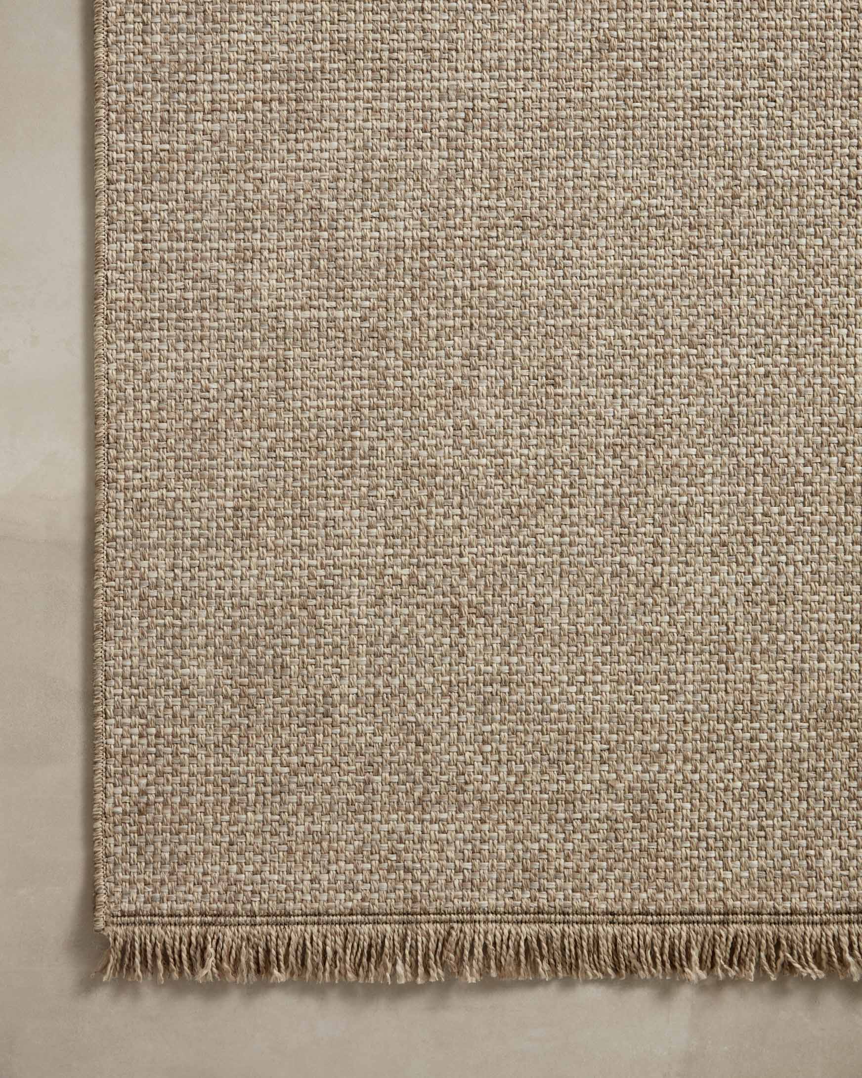 Natural woven rug panel with tight texture and short fringe edge on the bottom