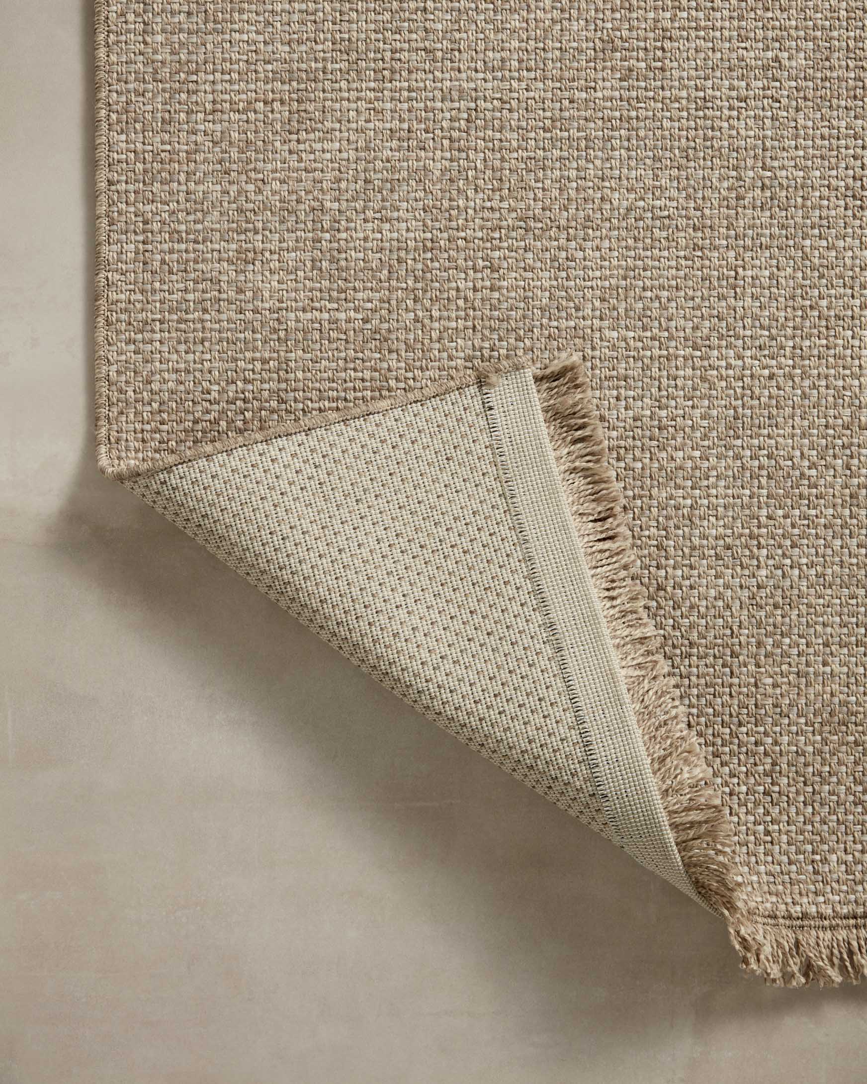 Beige flatwoven area rug with folded edge and short fringe trim