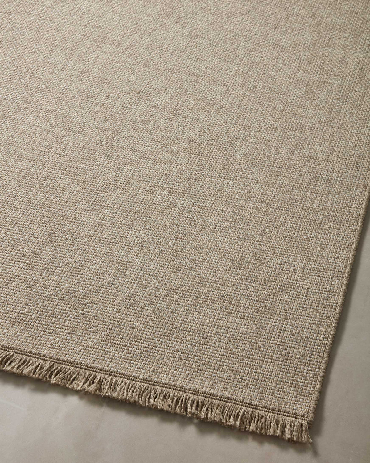 Natural woven runner rug with fringe border along the lower edge