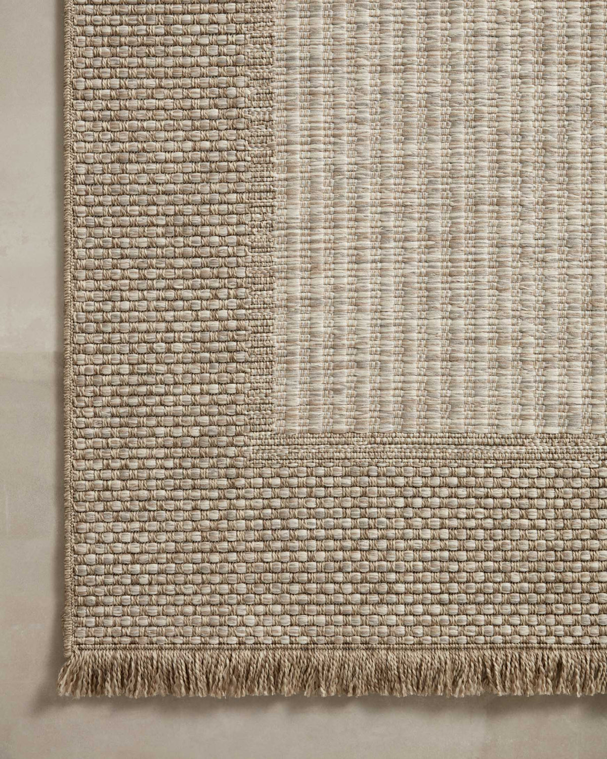 Natural woven runner rug showing two-tone grid blocks and fringed border edge