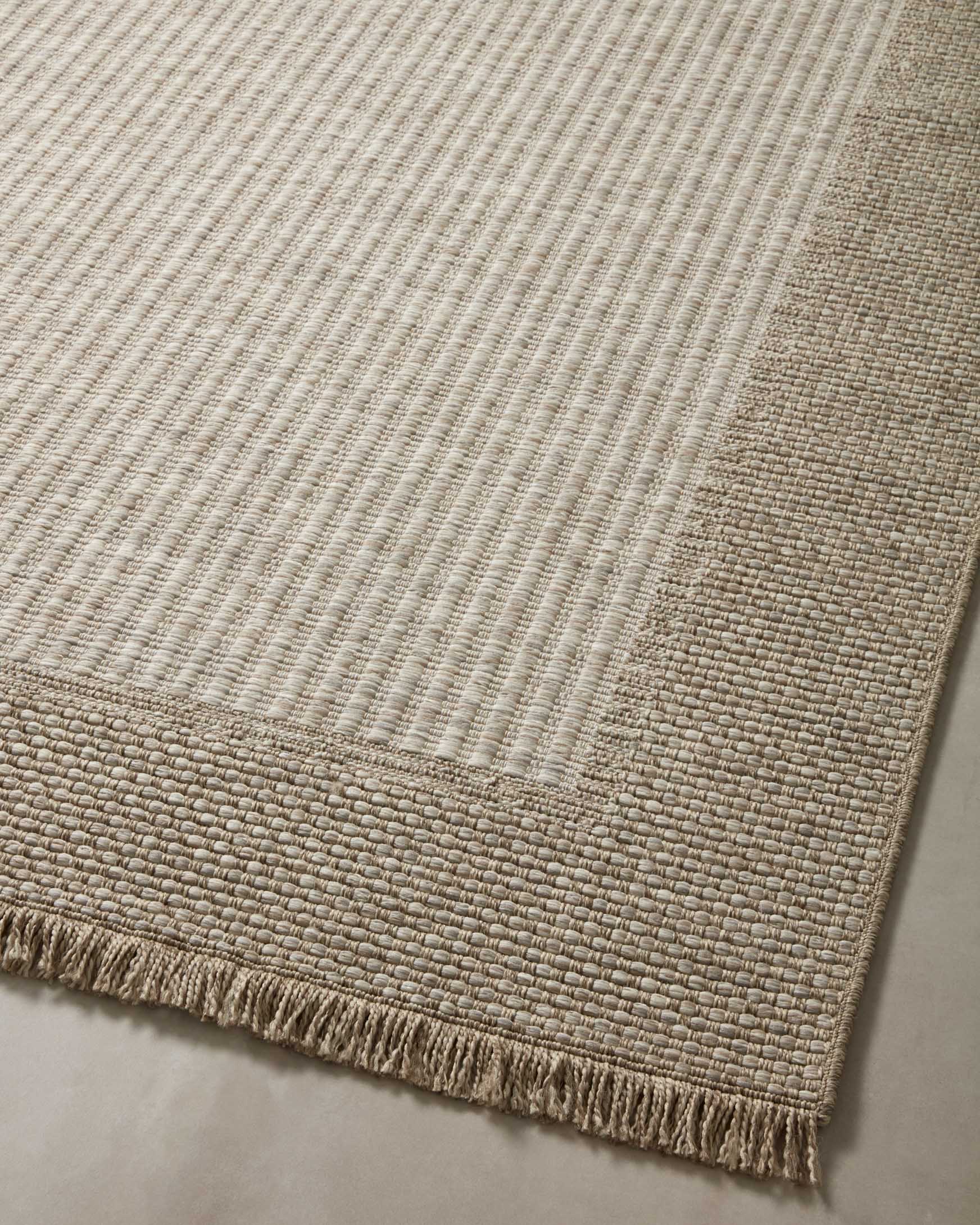 Natural accent rug flat view with grid-like weave, contrasting border, and short fringe