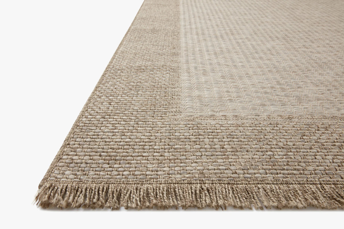 Natural accent rug with subtle woven texture, contrasting border, and short fringe edges