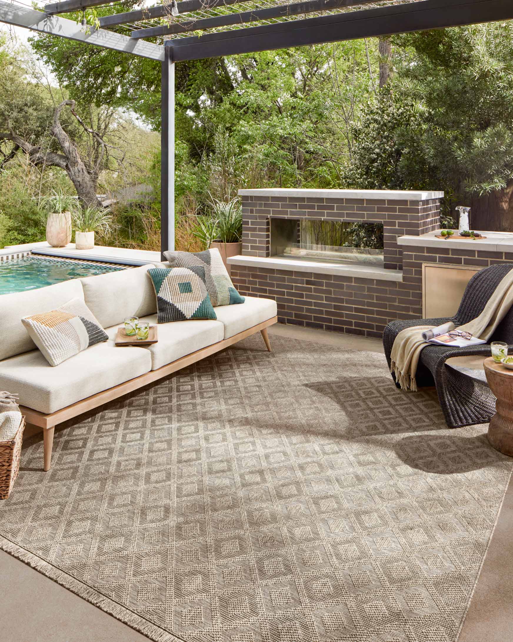 Natural area rug with geometric diamond pattern and fringed edges on patio