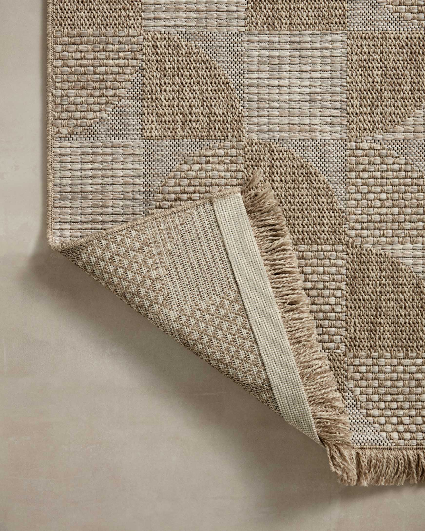 Loloi II natural accent rug corner with textured weave, folded edge, and short fringe