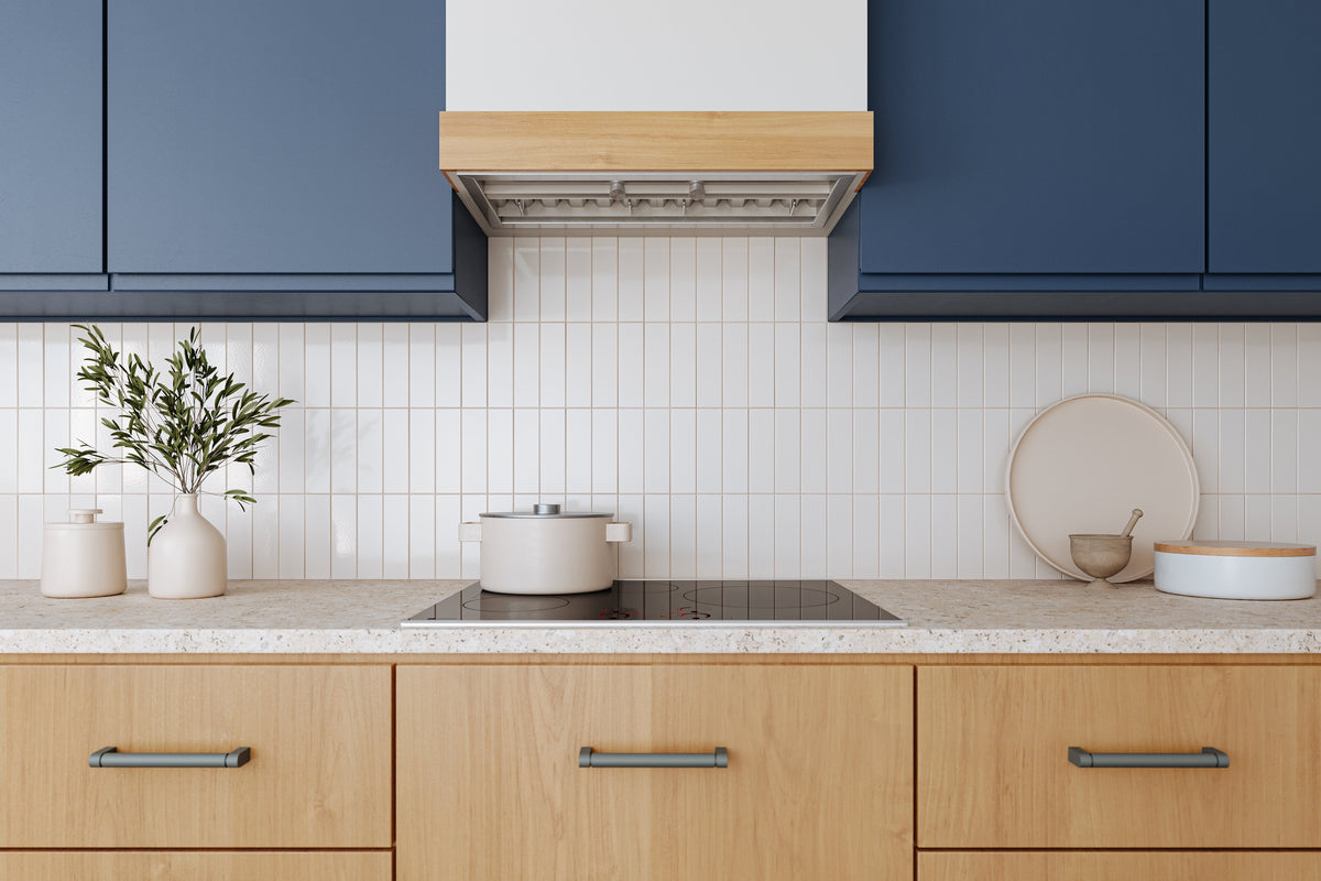 Stainless steel built-in range hood installed under cabinets above the cooktop