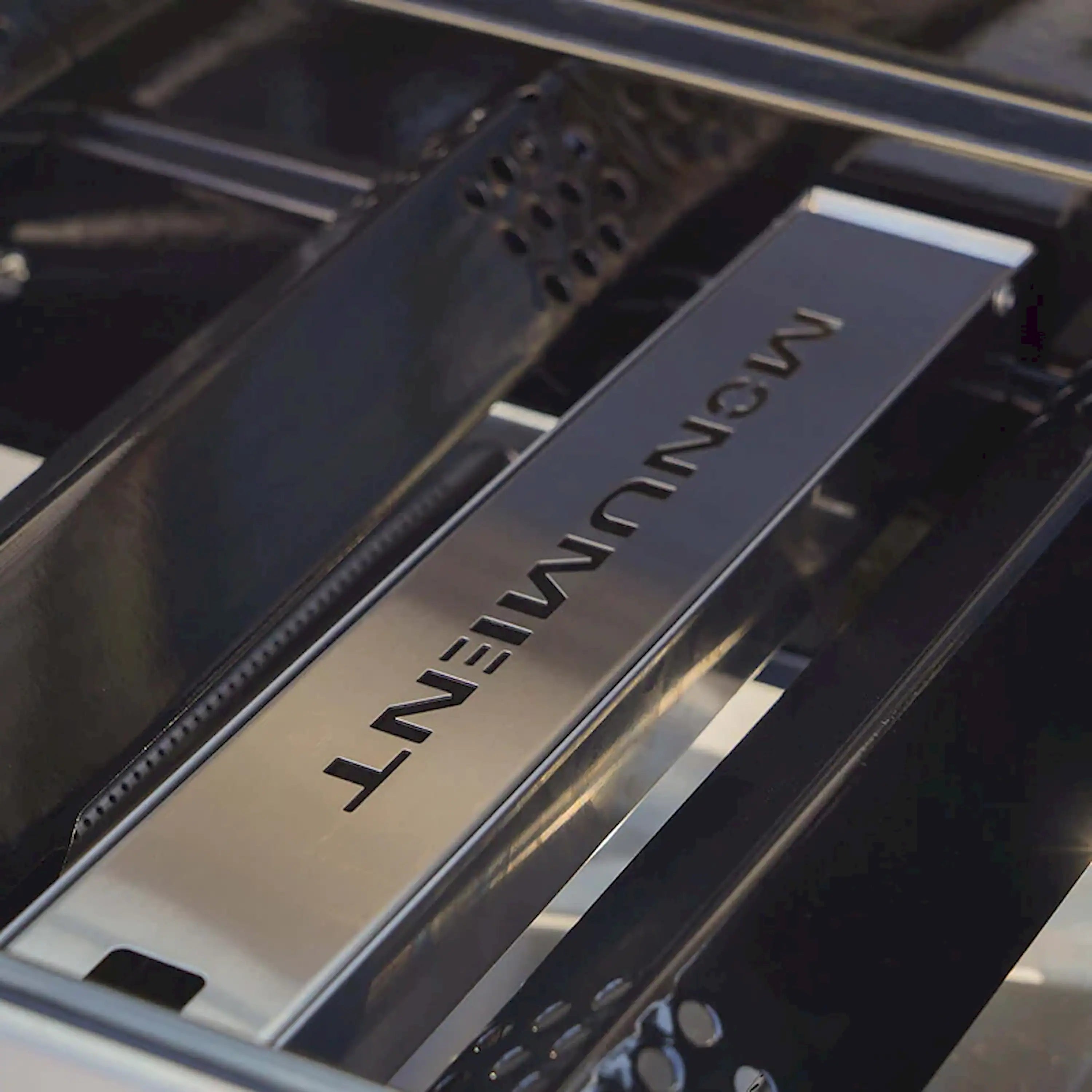 Stainless steel smoker box insert with raised MONUMENT lettering and vent holes