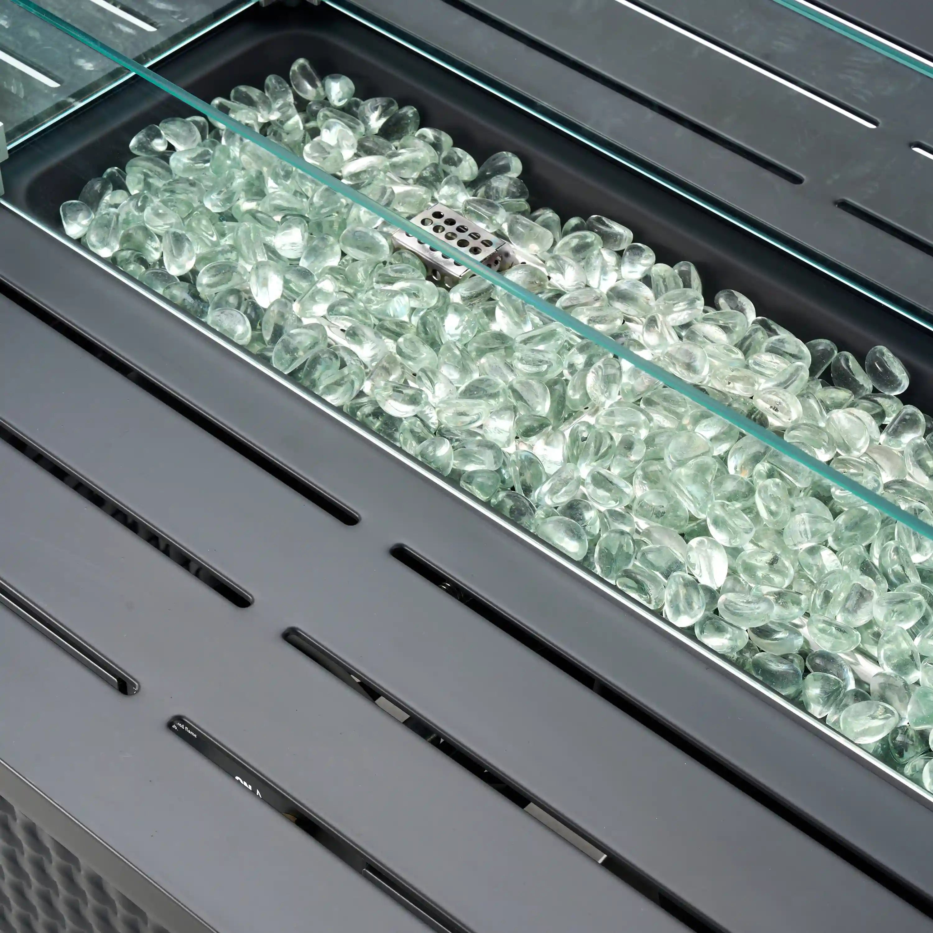 Fire pit burner bed filled with clear glass fire media under glass cover