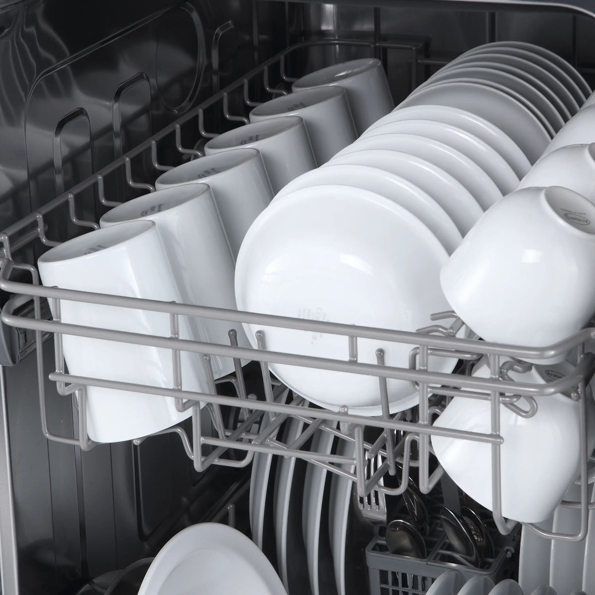 Dishwasher interior with white racks and spray arms for washing dishes