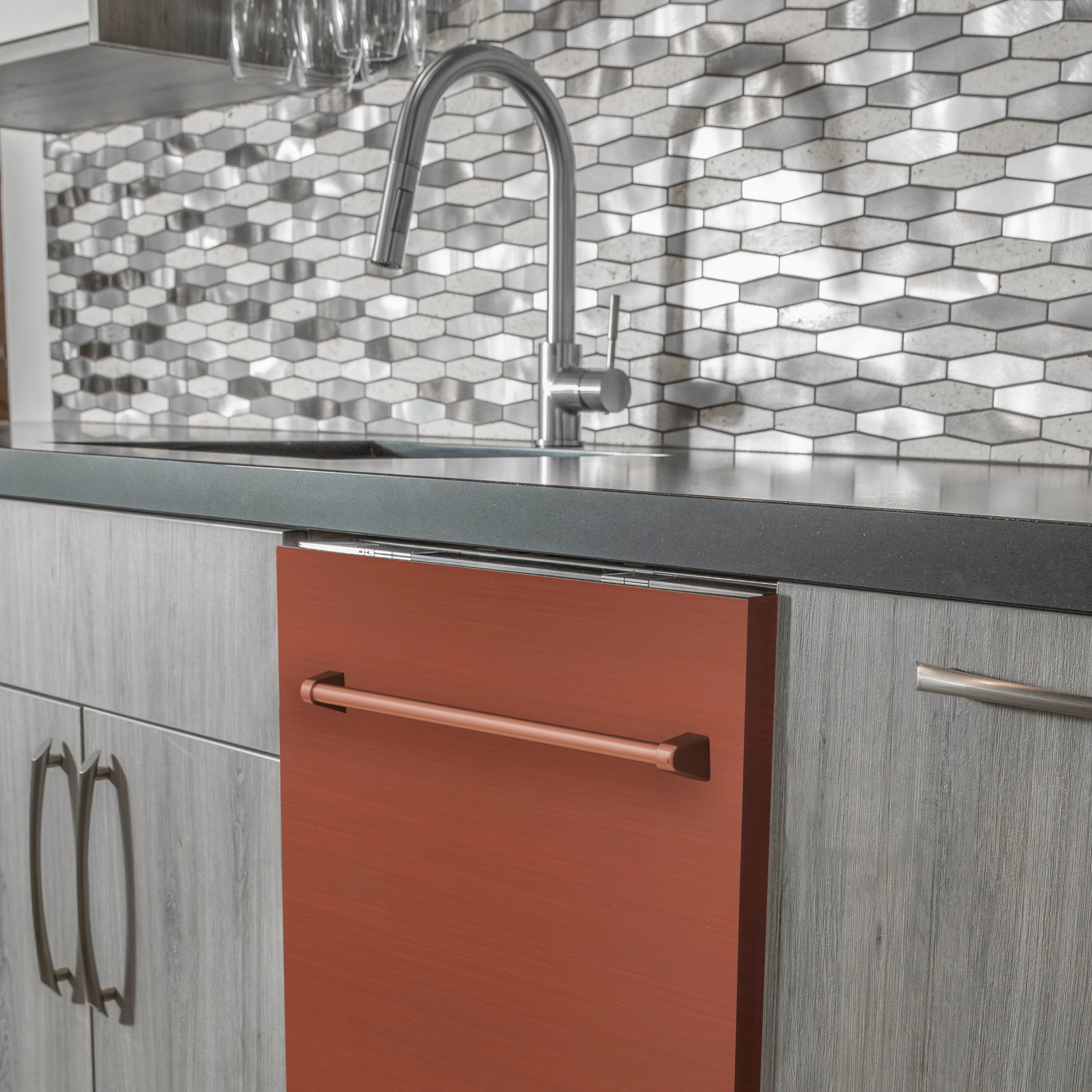 Built-in copper dishwasher door with stainless handle in front of kitchen countertop