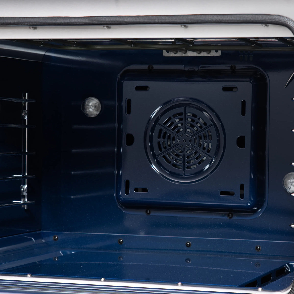 Convection oven interior with dark rear vent panel and oven racks inside the range