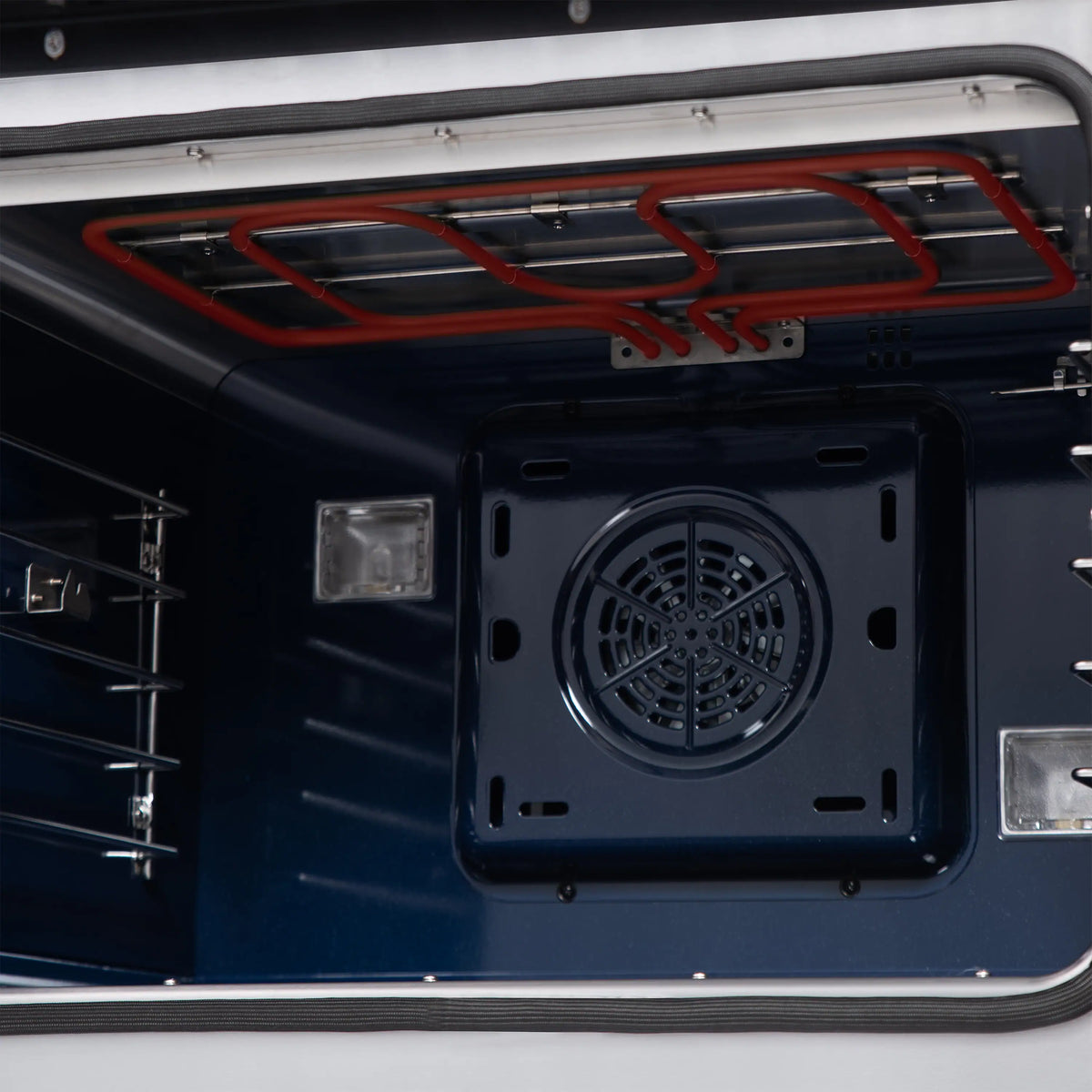 Dual fuel range oven interior close-up with red gas lines and ventilation opening