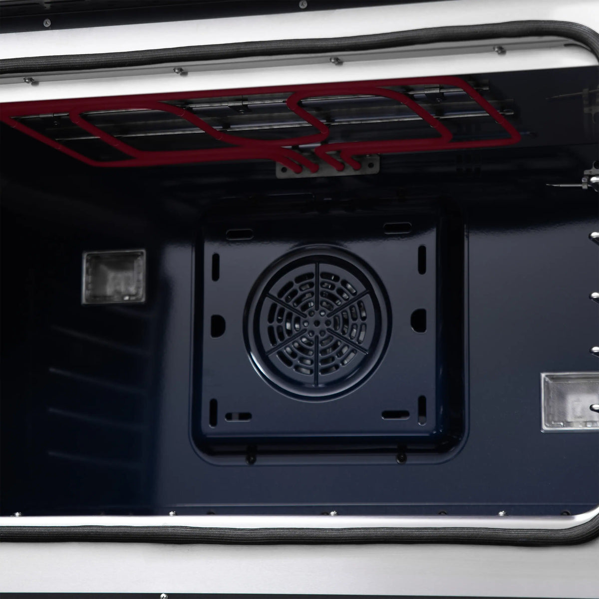 Freestanding dual fuel range oven interior with circular fan vent and red heating element