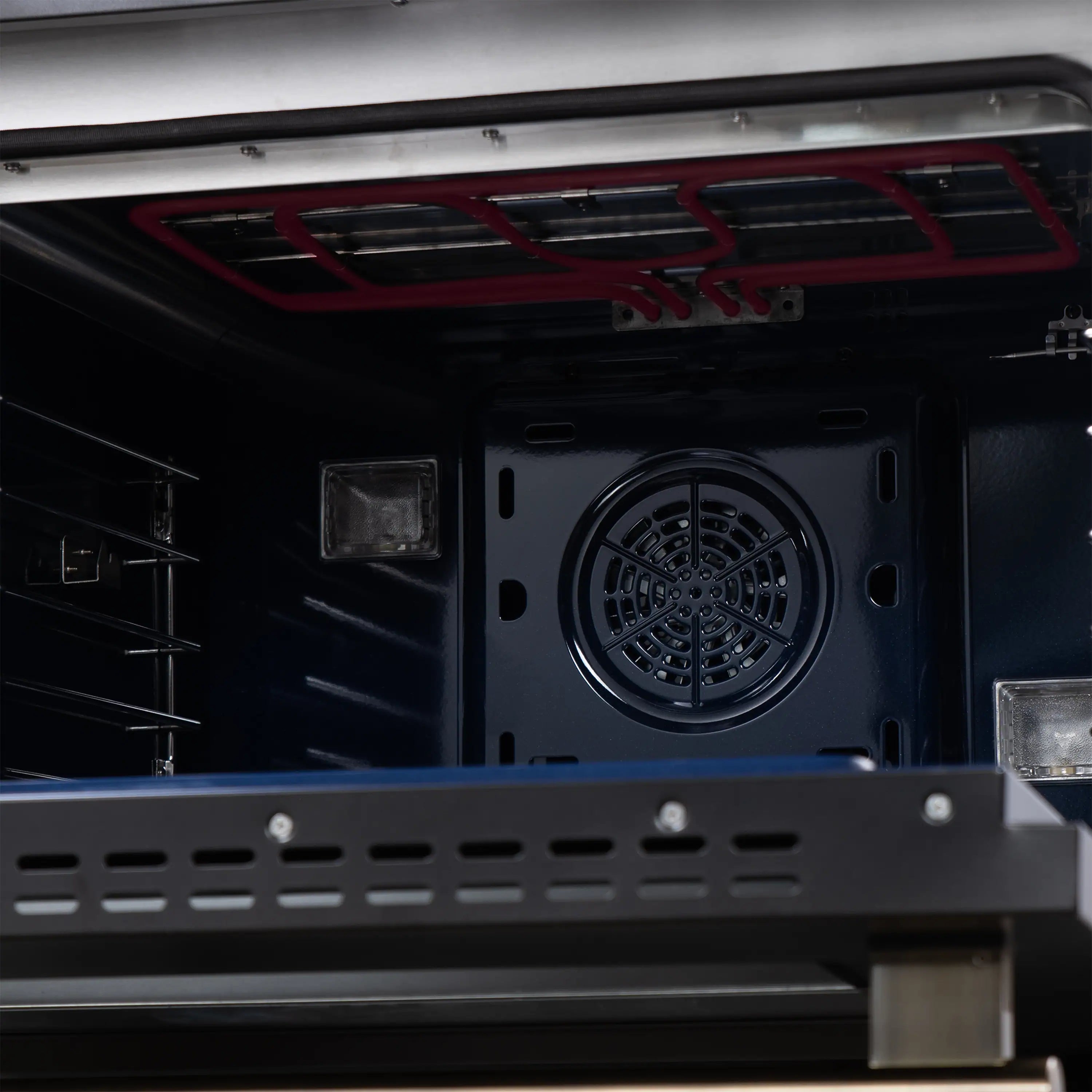 Freestanding range rear oven vent with circular fan and grates, black interior.