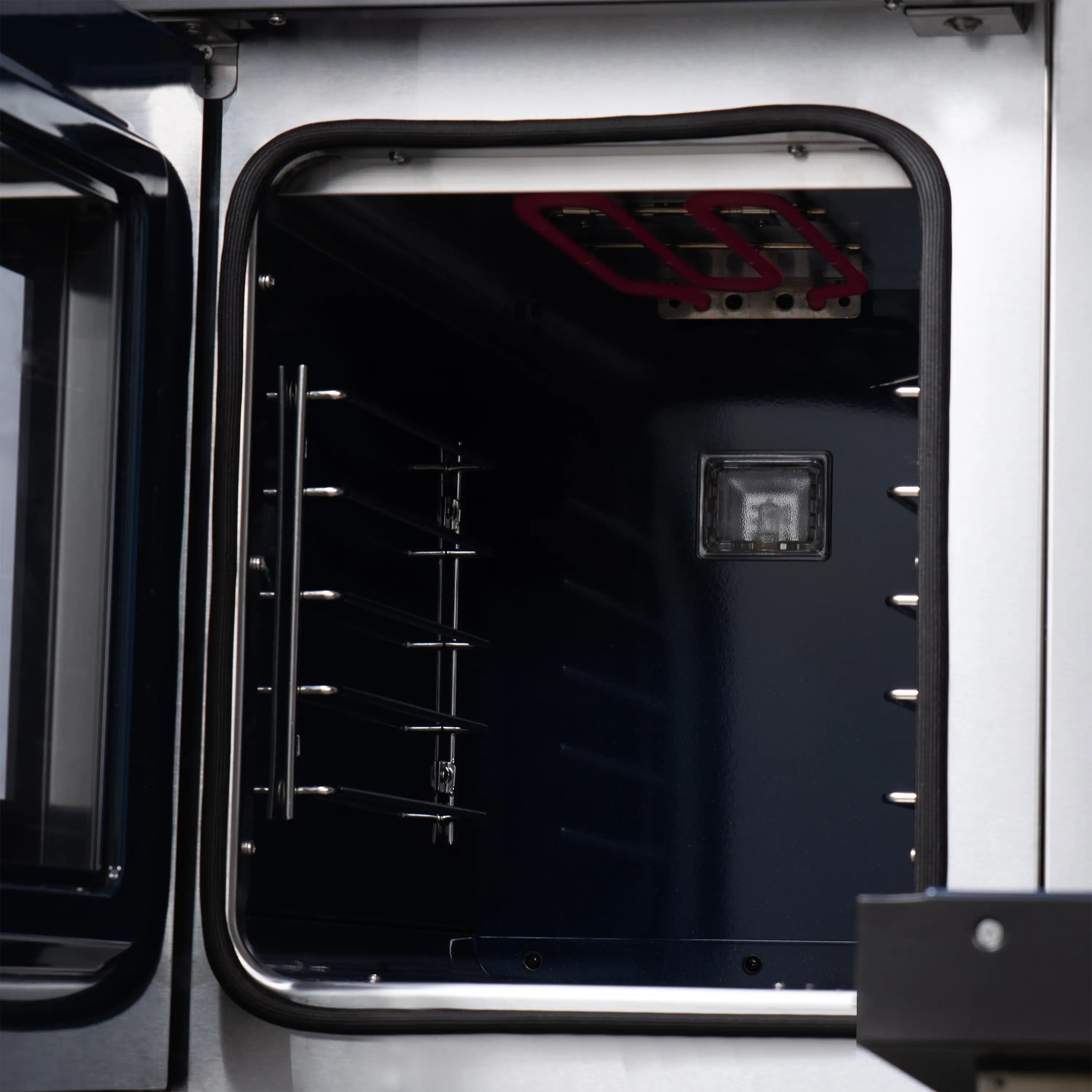 Freestanding dual fuel range with open oven door and dark interior racks