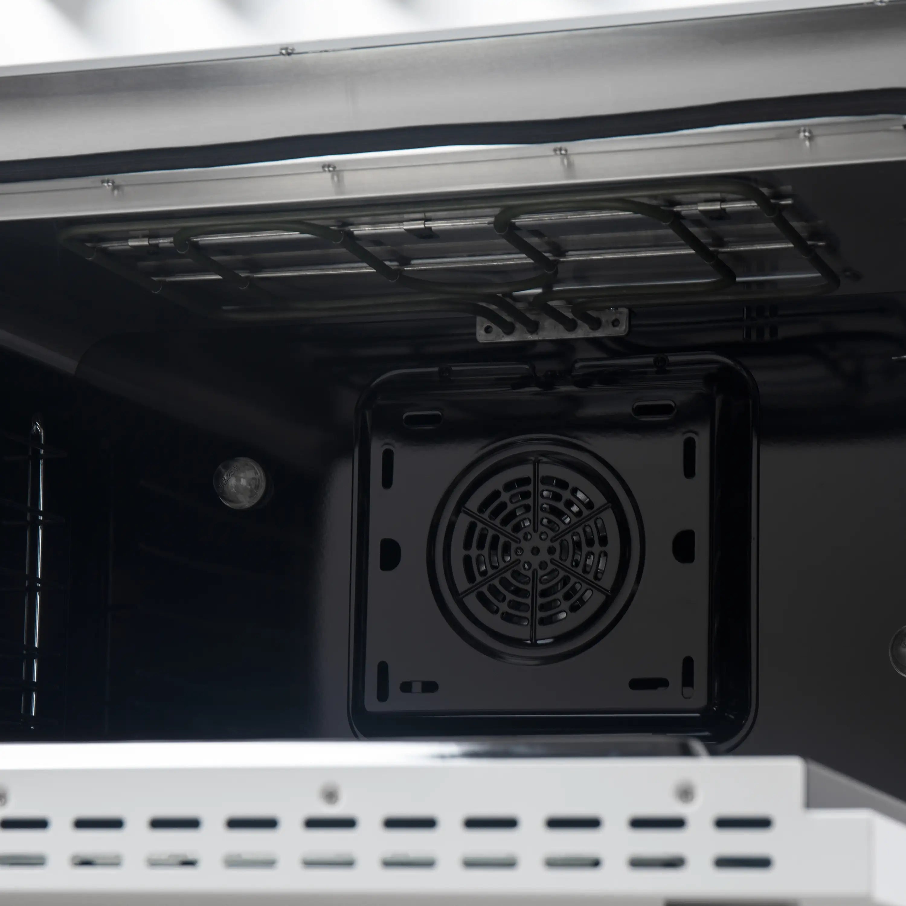 Dual fuel oven interior with black cavity and rear circular vent cover