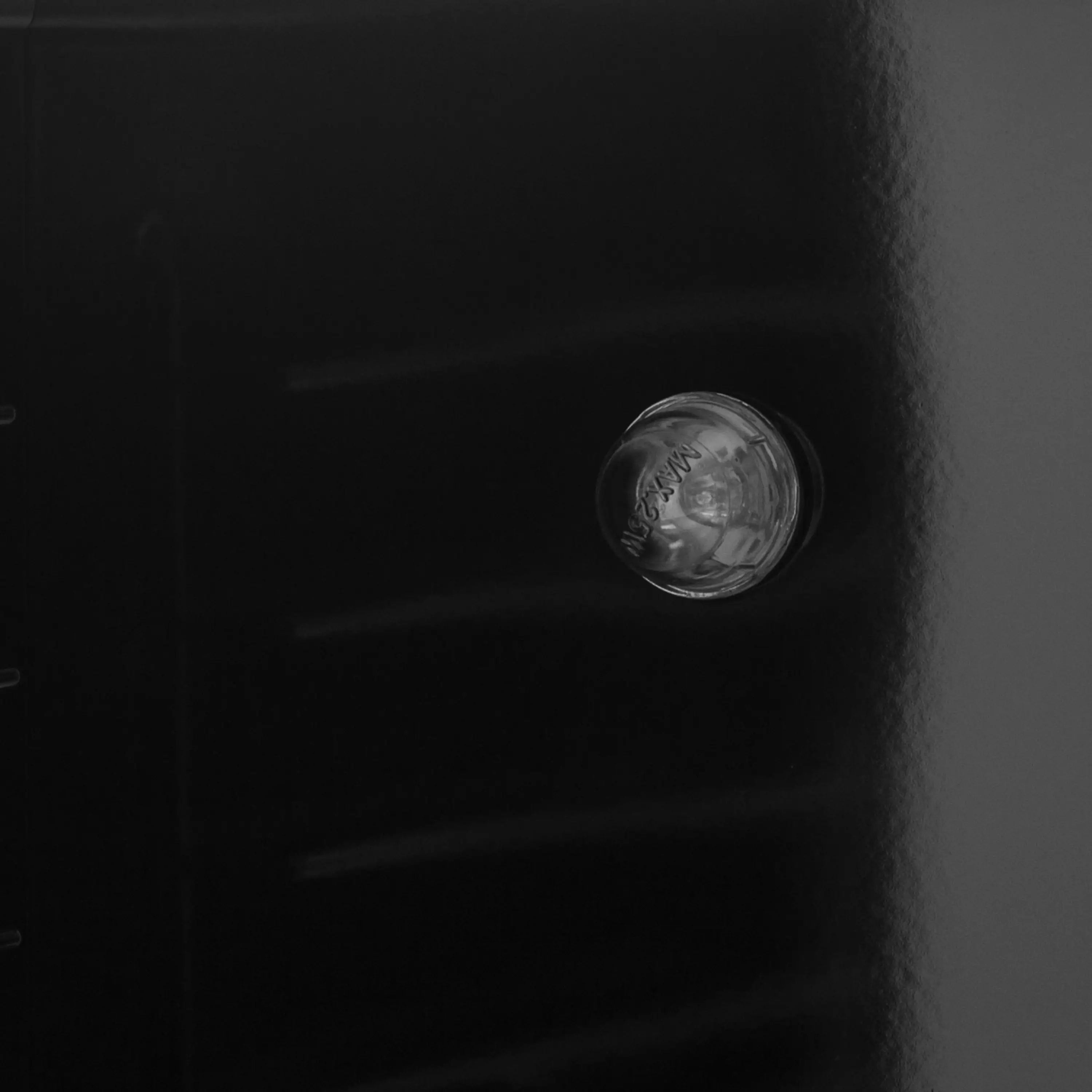 Logo on dark oven door panel with textured surface