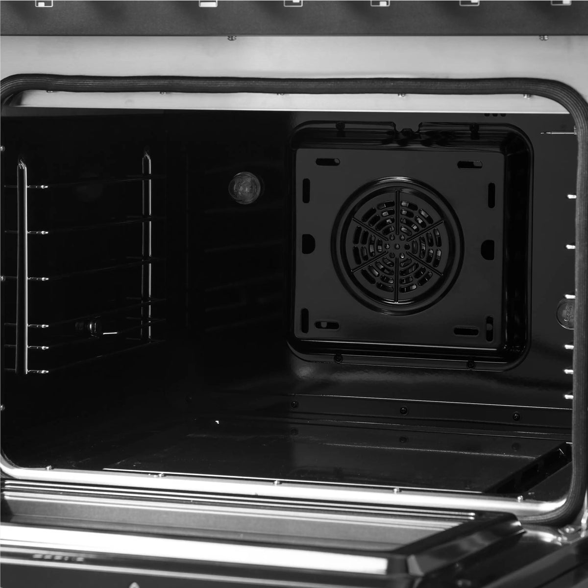 Close-up of oven cavity with circular fan and wire racks inside the black oven