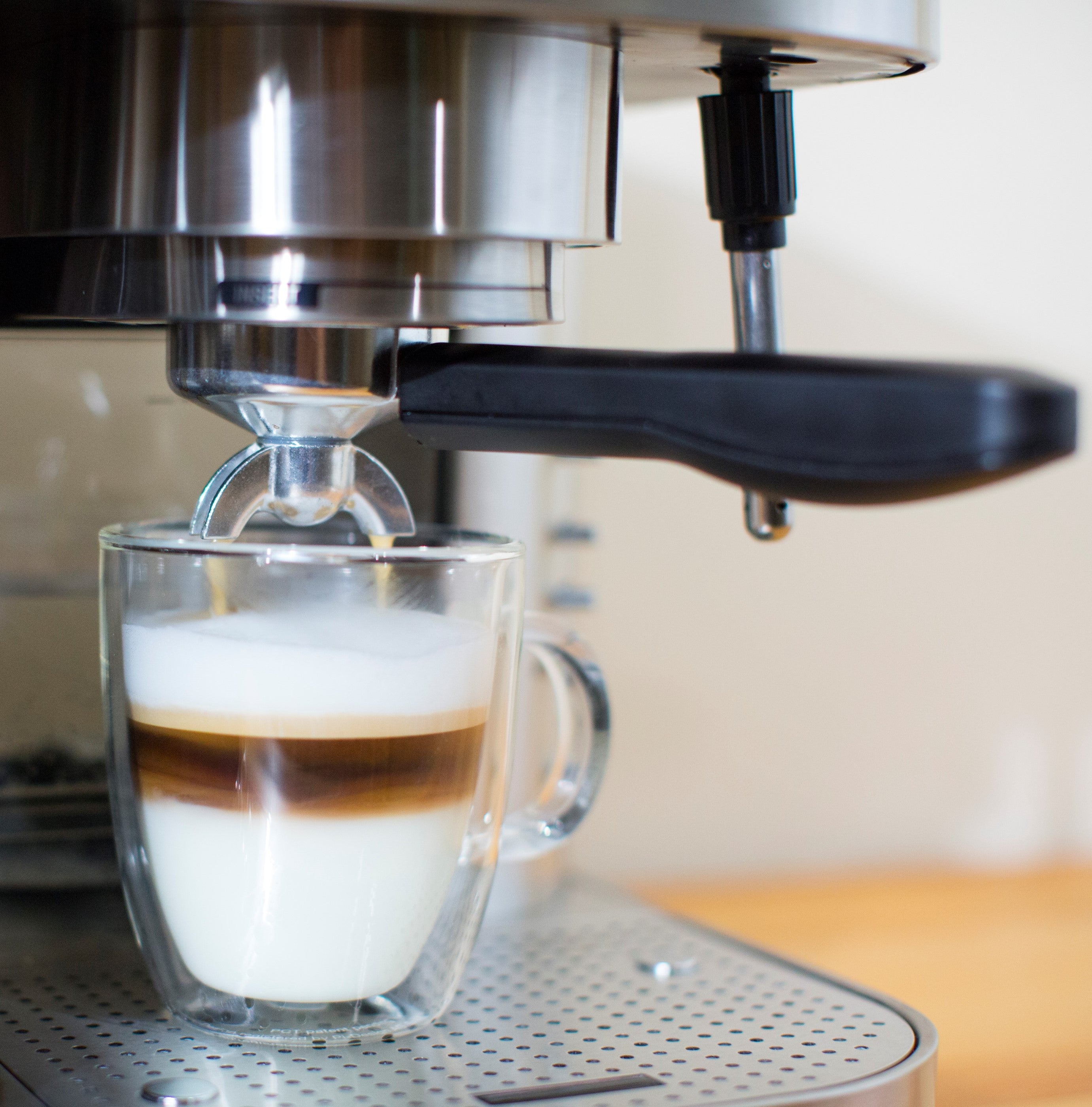 Espressione stainless steel espresso machine with glass cup on perforated drip tray