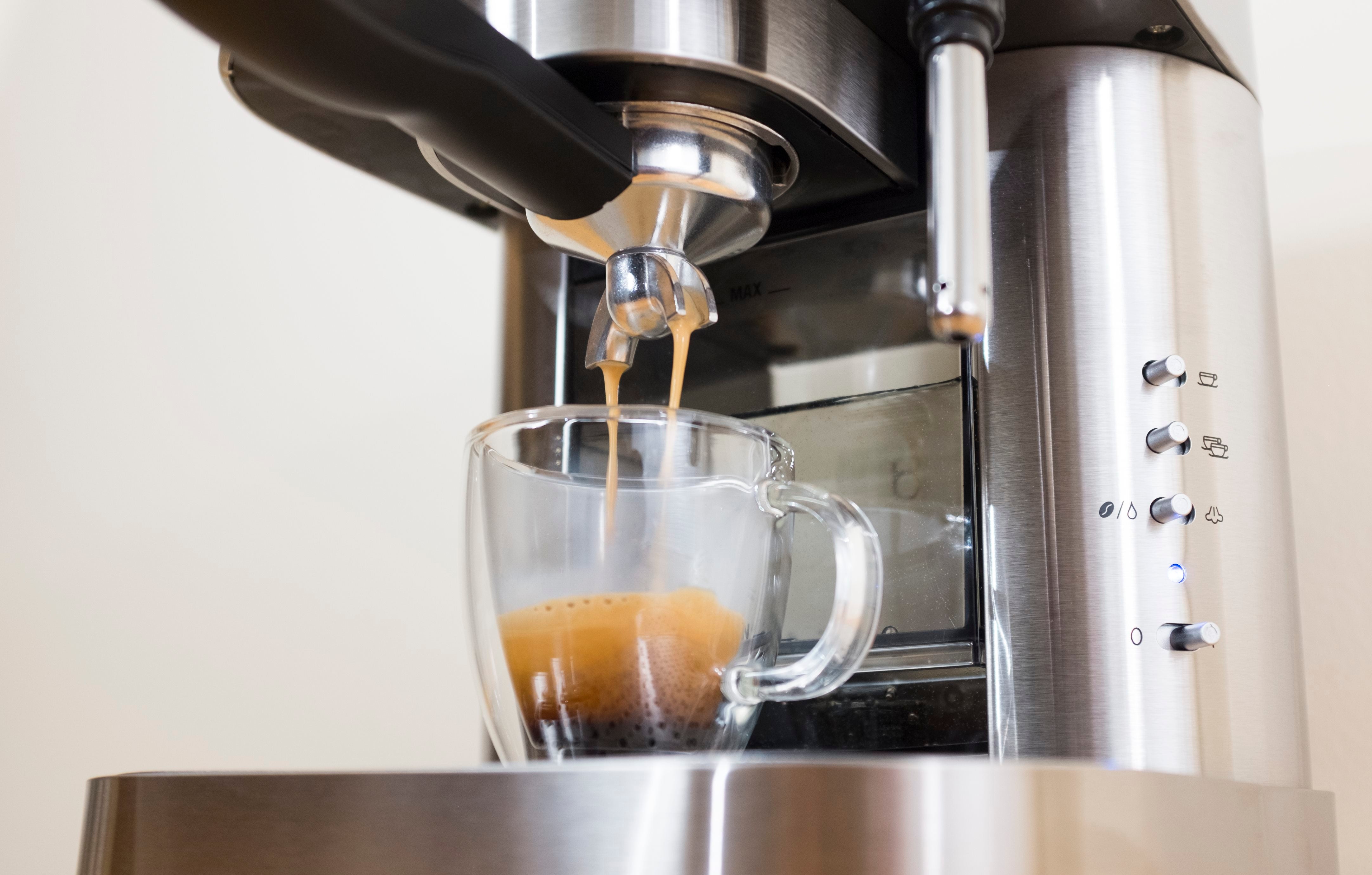 Espressione stainless steel espresso machine brewing espresso into glass cup